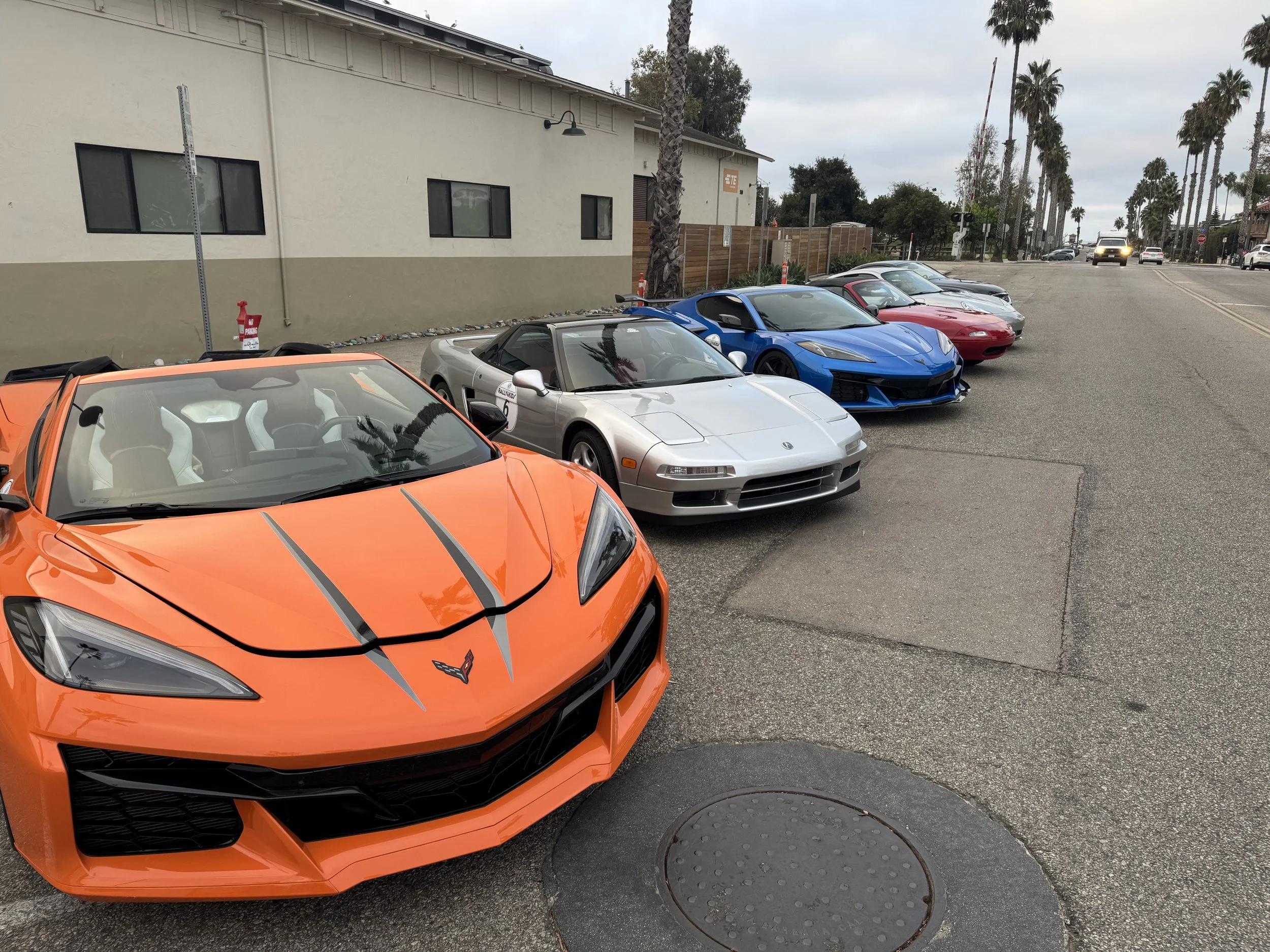 orange-convertible-sports-car-parked-in-front-of-silver-and-blue-cars--8be5214f.jpeg