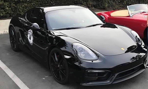Black Porsche sports car parked in a parking lot.