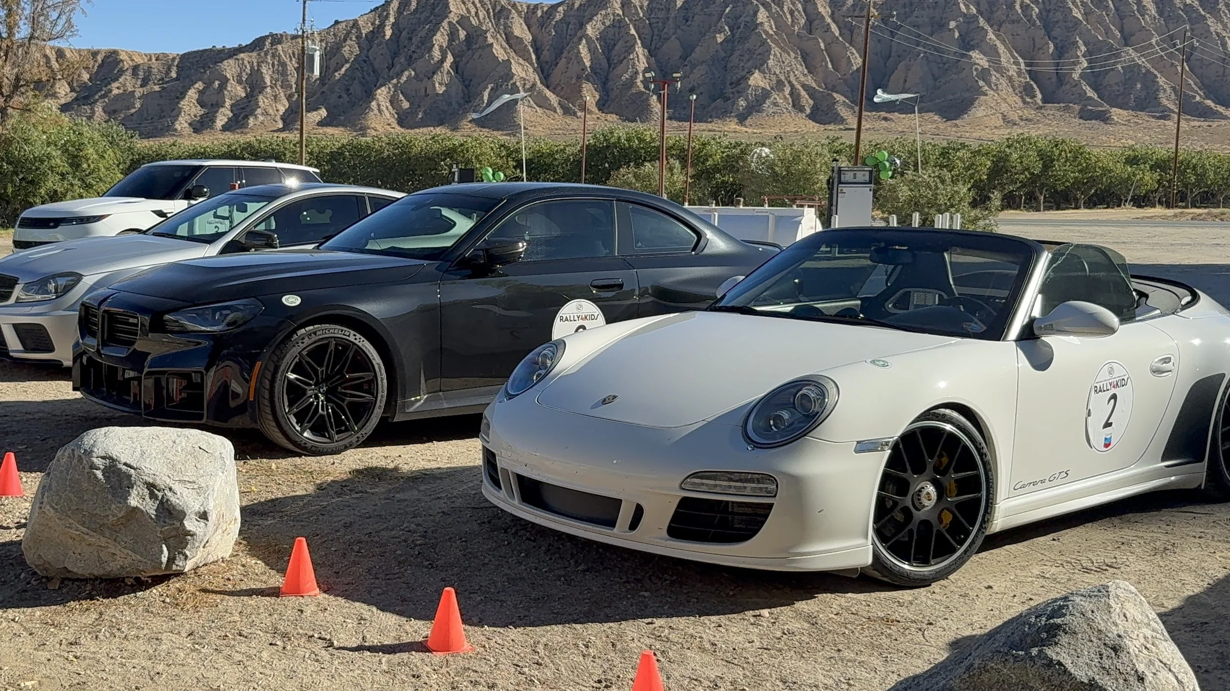 white-convertible-sports-car-with-number-2-parked-next-to-black-coupe--f99cdd99.jpeg