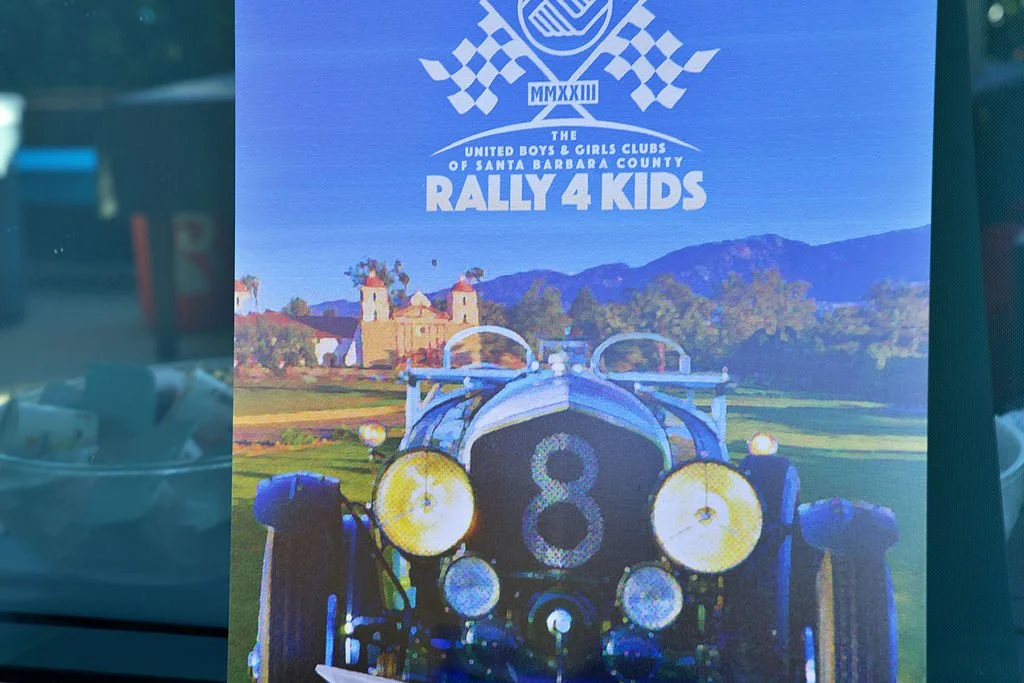 Poster for the Rally for Kids event, organized by the United Boys & Girls Clubs of Santa Barbara County, featuring a vintage race car and a scenic background of mountains and a building.