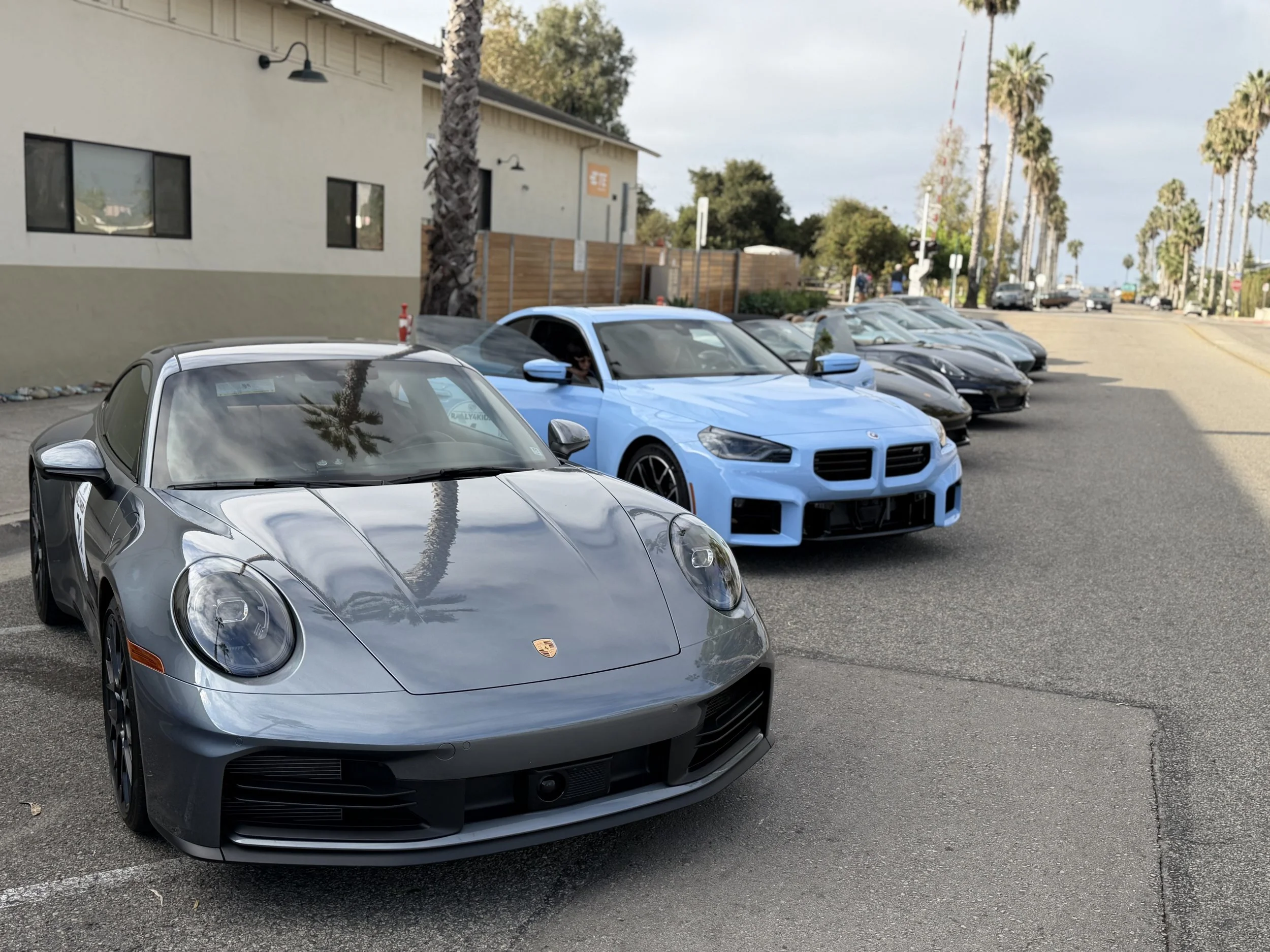 silver-porsche-beside-blue-bmw-outside-rally-gathering--25c4ea78.jpeg