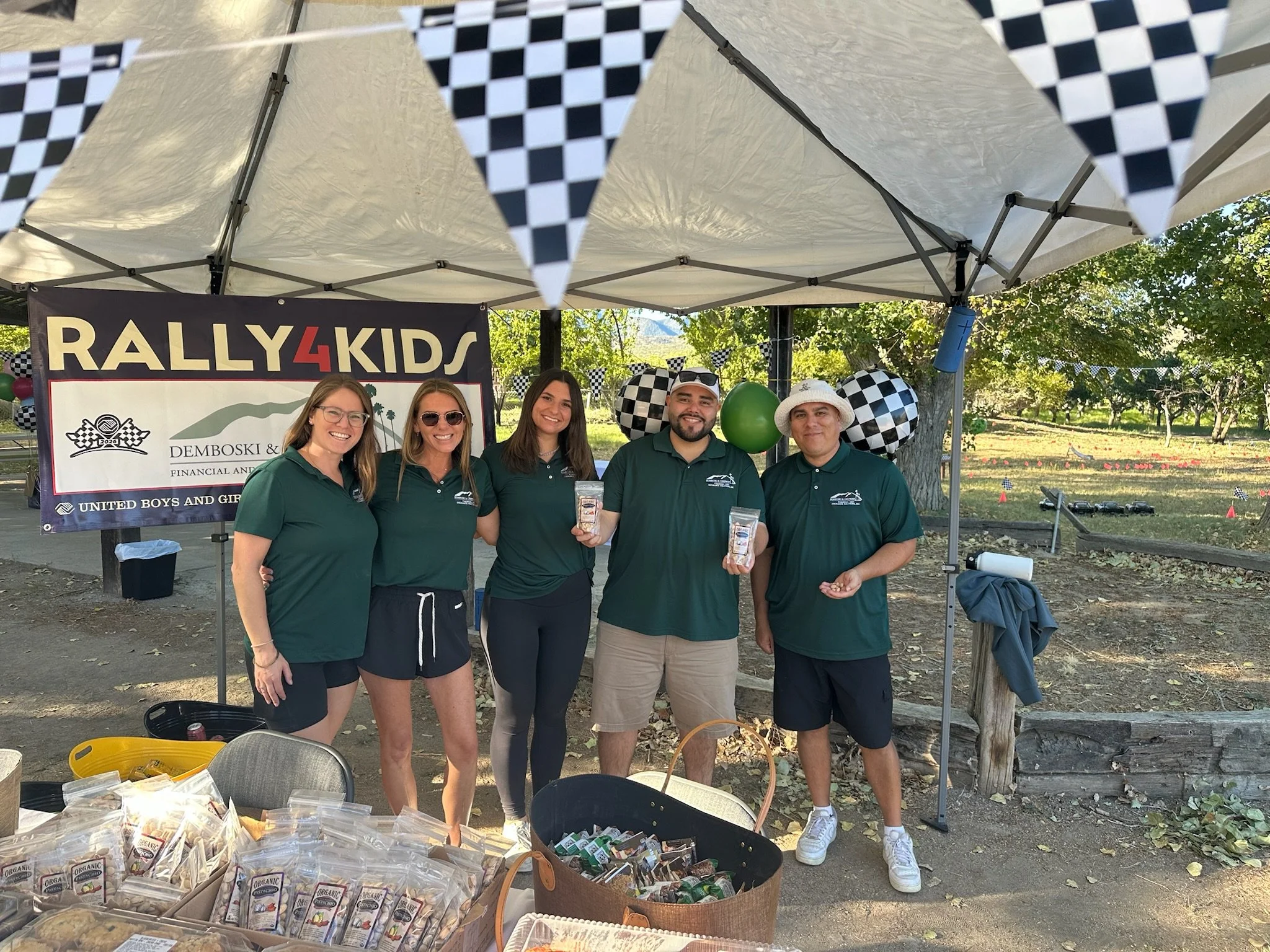 five-people-in-green-shirts-under-a-tent-with-a-rally4kids-banner--ace57ac8.jpeg