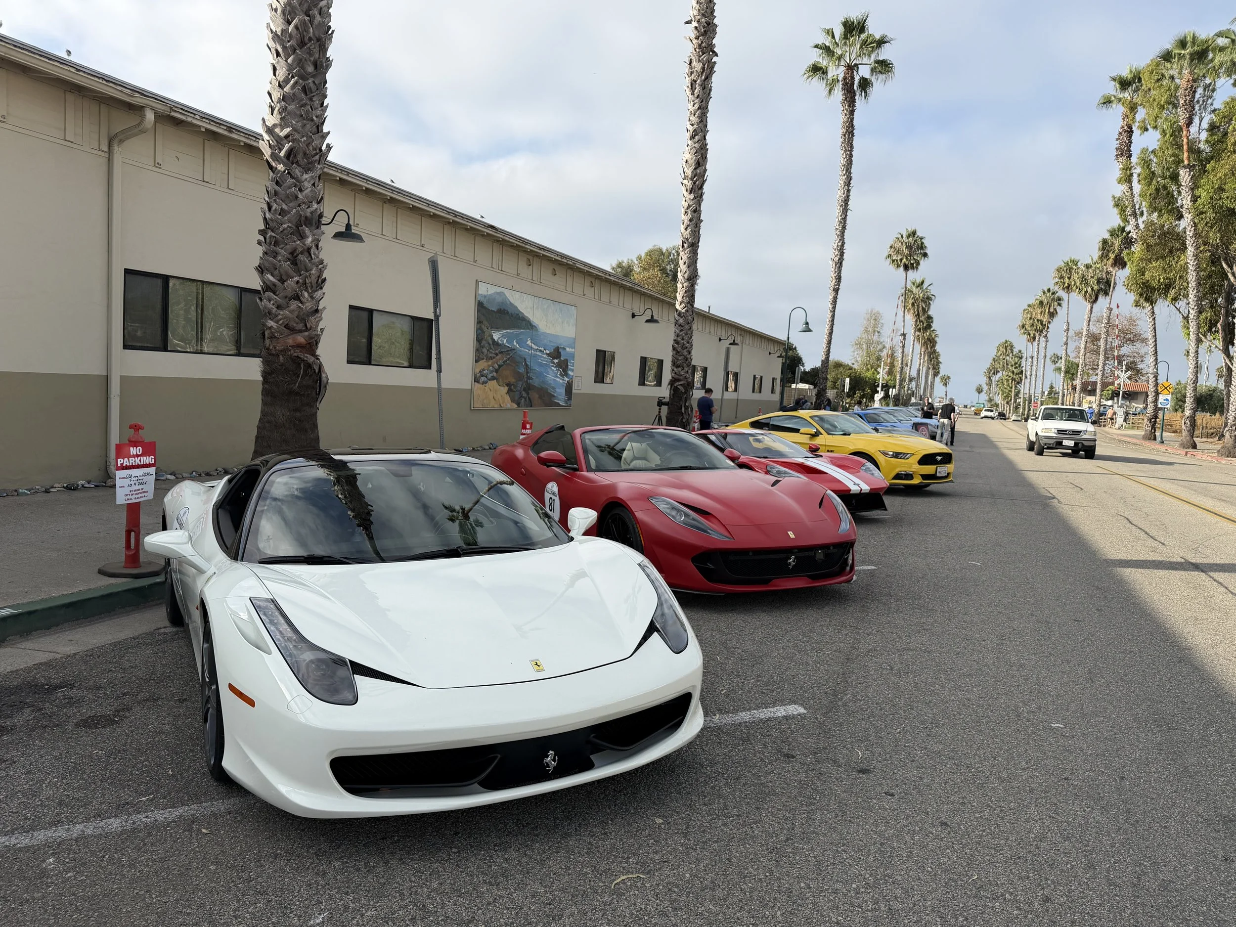 white-ferrari-ahead-of-red-and-yellow-sports-cars--9c2e265a.jpeg