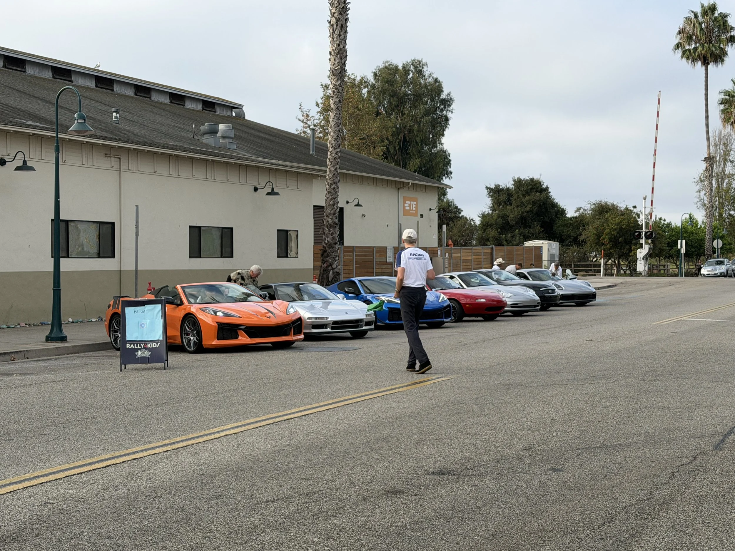man-crossing-street-in-front-of-colorful-sports-car-lineup--255180df.jpeg