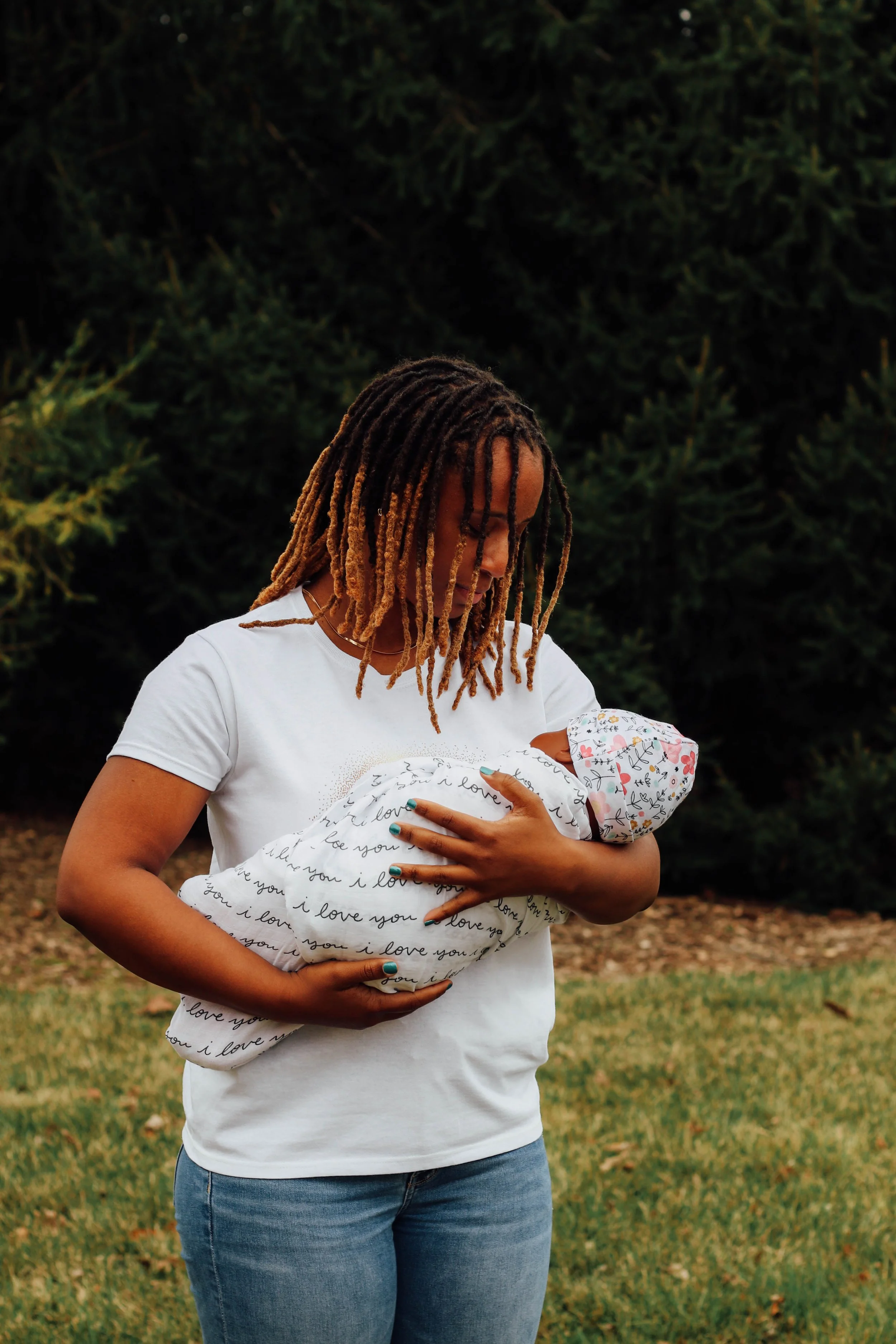 Postpartum doula gently holding a swaddled newborn — compassionate fourth trimester support in DC, Maryland, and Virginia.