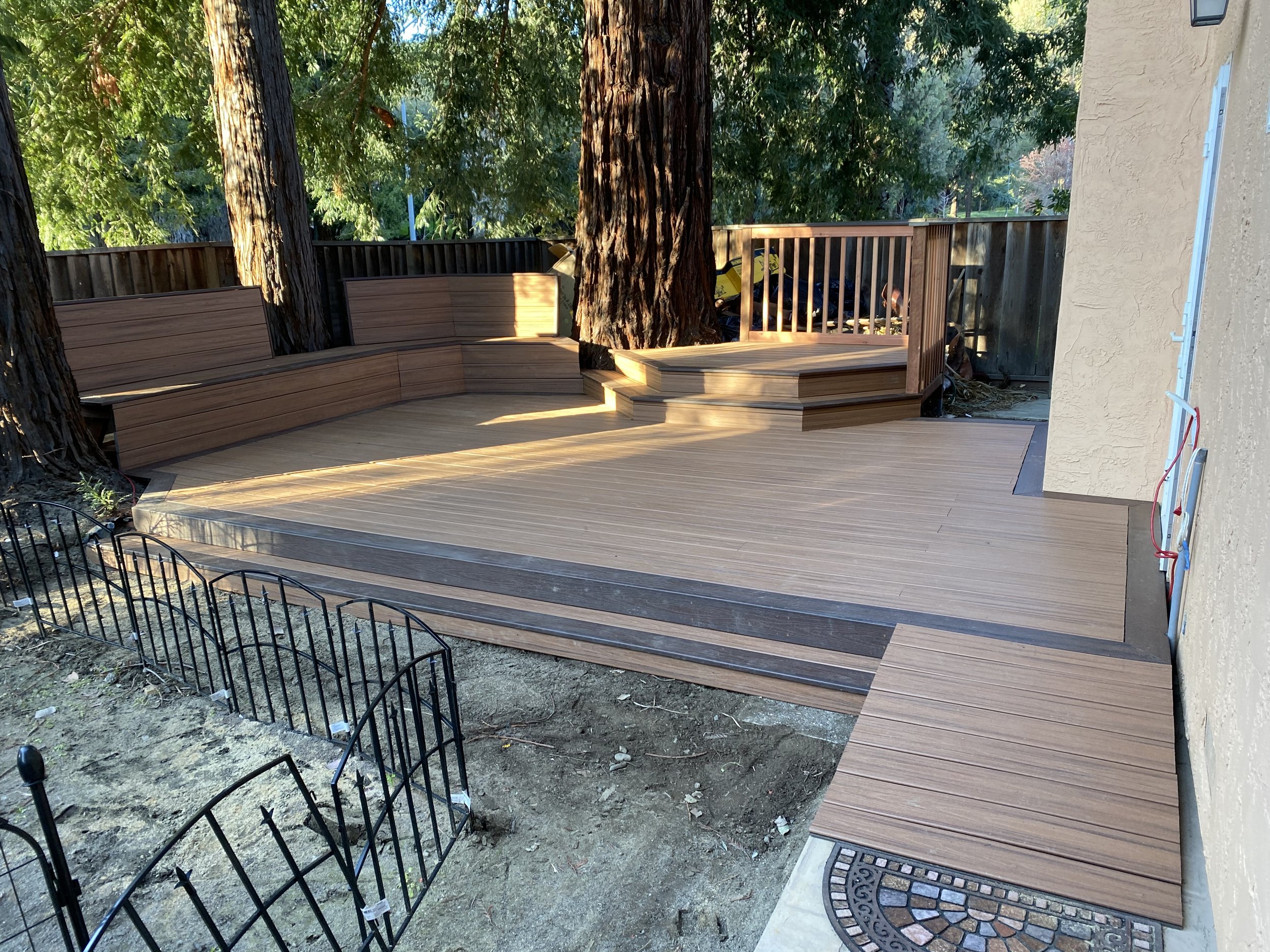 Custom designed 60ft deck molded into redwood trees in backyard 