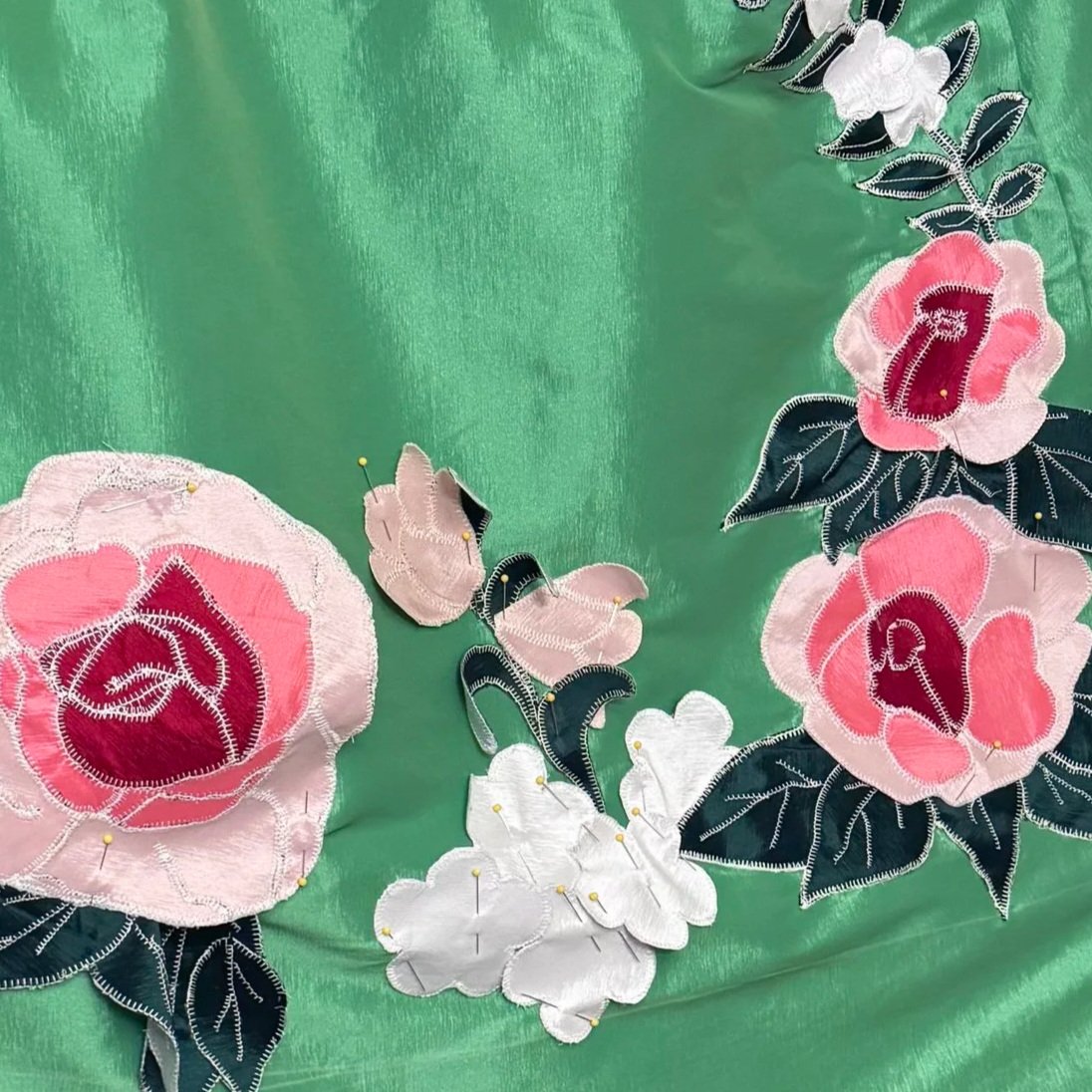 A close up view of the hand-drawn, hand-cut applique flowers adorning the wrap skirt.