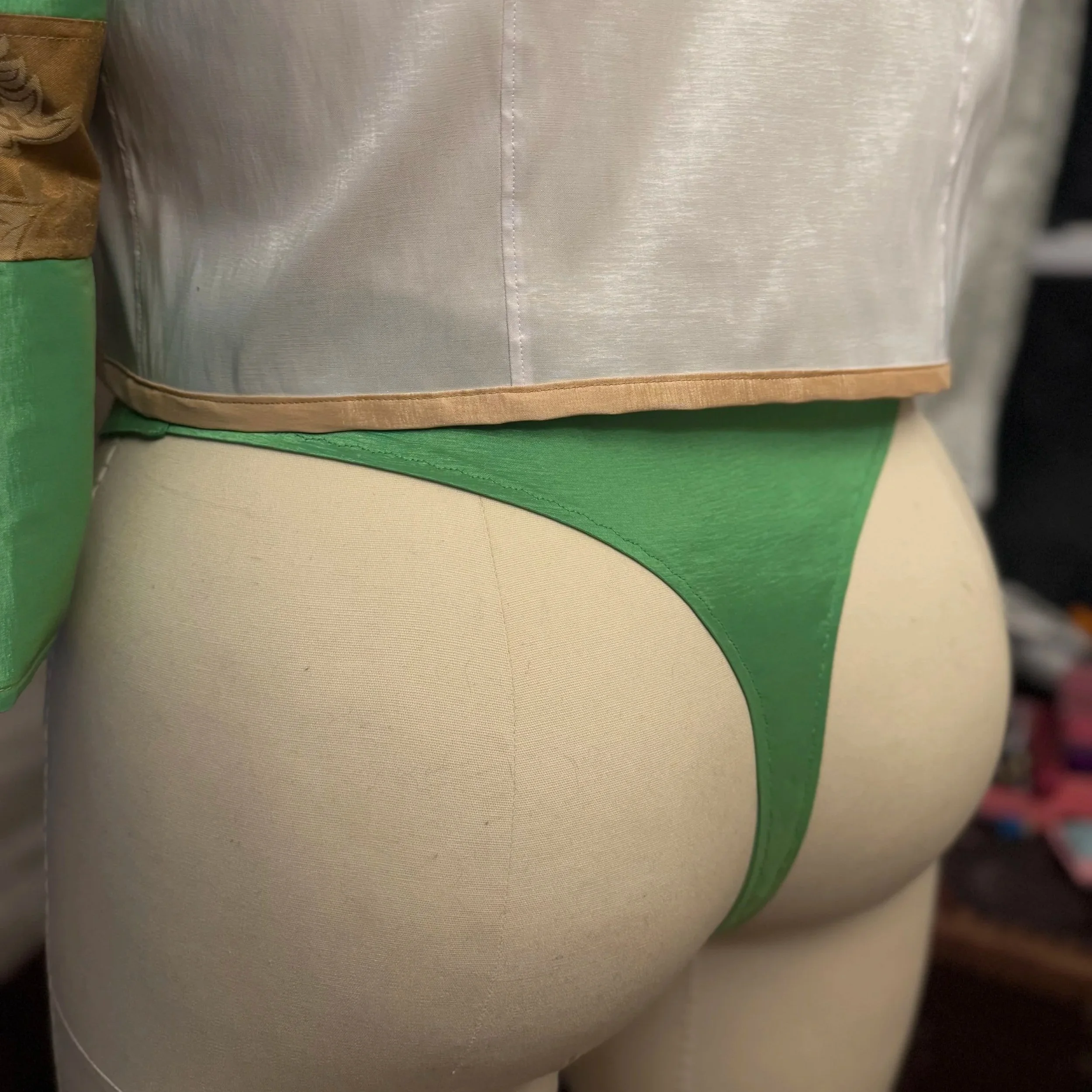 Detail view of rear costume view with bespoke burlesque thong panty and crop jacket with sleeves attached.