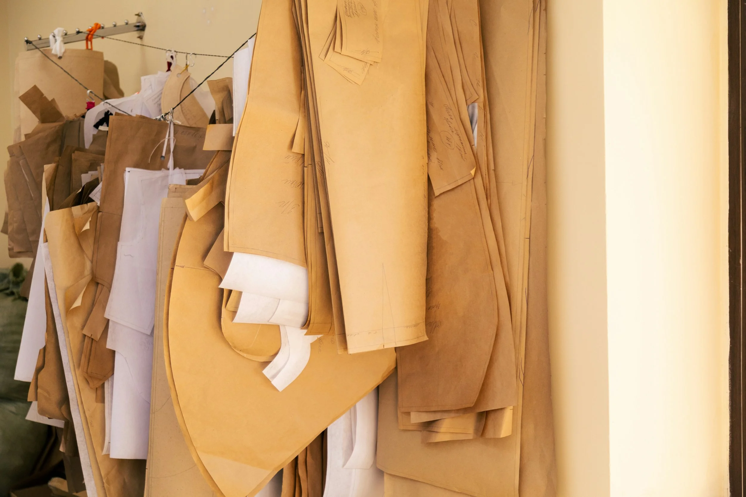 A large hanging rack of brown, butcher paper sewing patterns.
