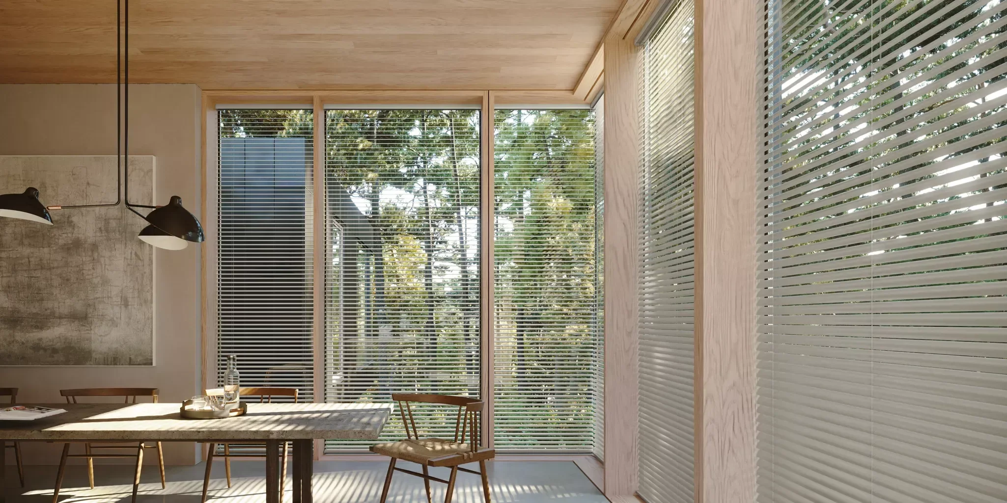Interior view of a modern room with large windows covered with horizontal blinds, wooden ceiling, minimalist decor, a wooden table, and chairs, sunlight casting shadows.