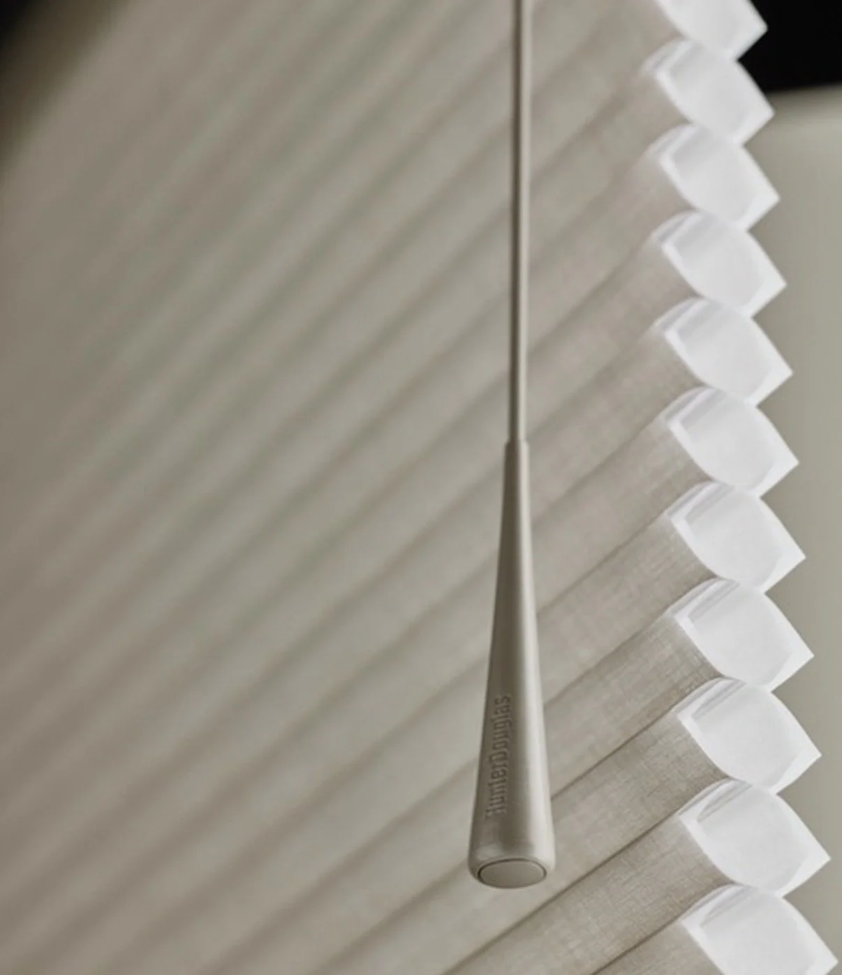 Close-up of a stainless steel tone whistle hanging from white blinds window.