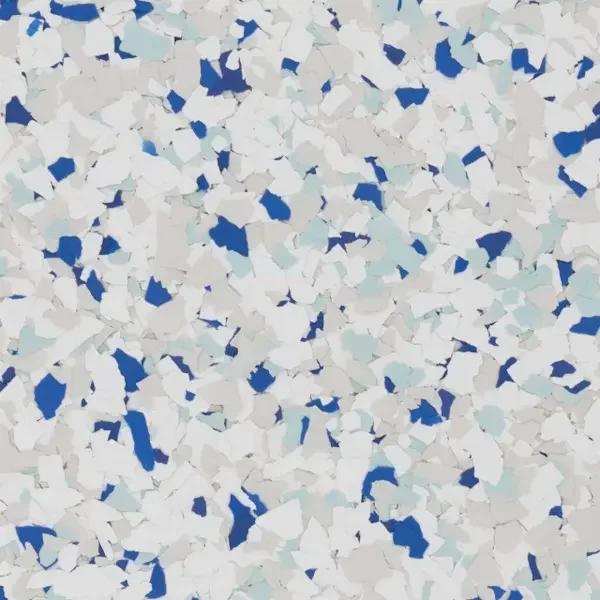 Close-up of a speckled textured surface with white, light gray, and dark blue fragments, resembling epoxy floor flakes.