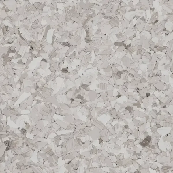 Close-up of white shredded epoxy floor flakes scattered on a surface.
