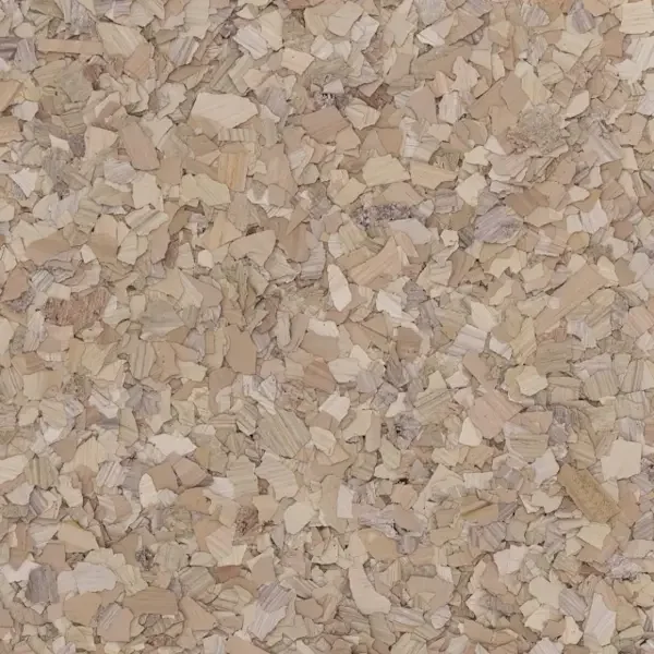 Close-up of a textured surface with small, irregularly shaped, beige-colored wood shavings or chips.