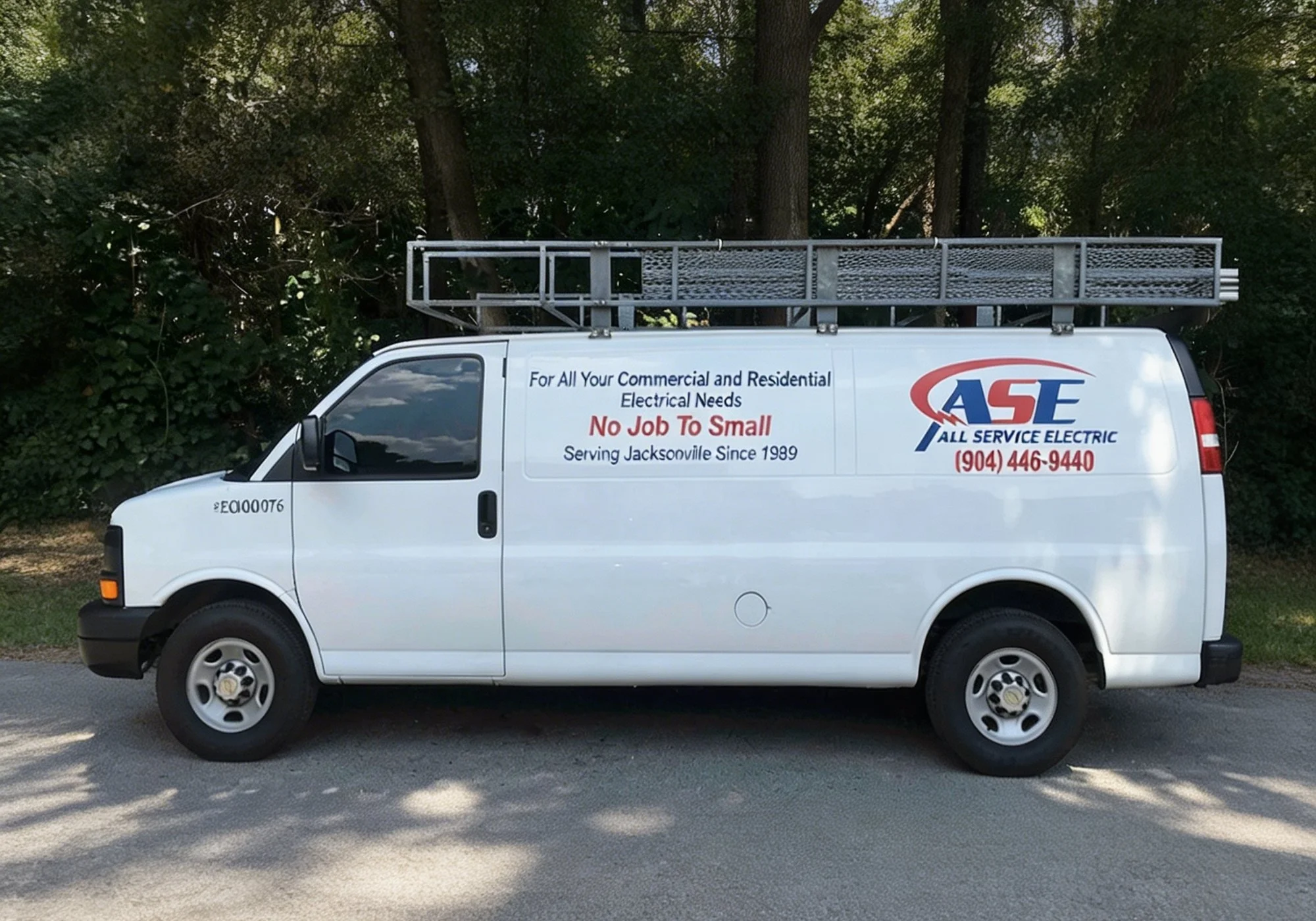 White service van parked outdoors with a ladder on top and advertisements for electrical services on the side.