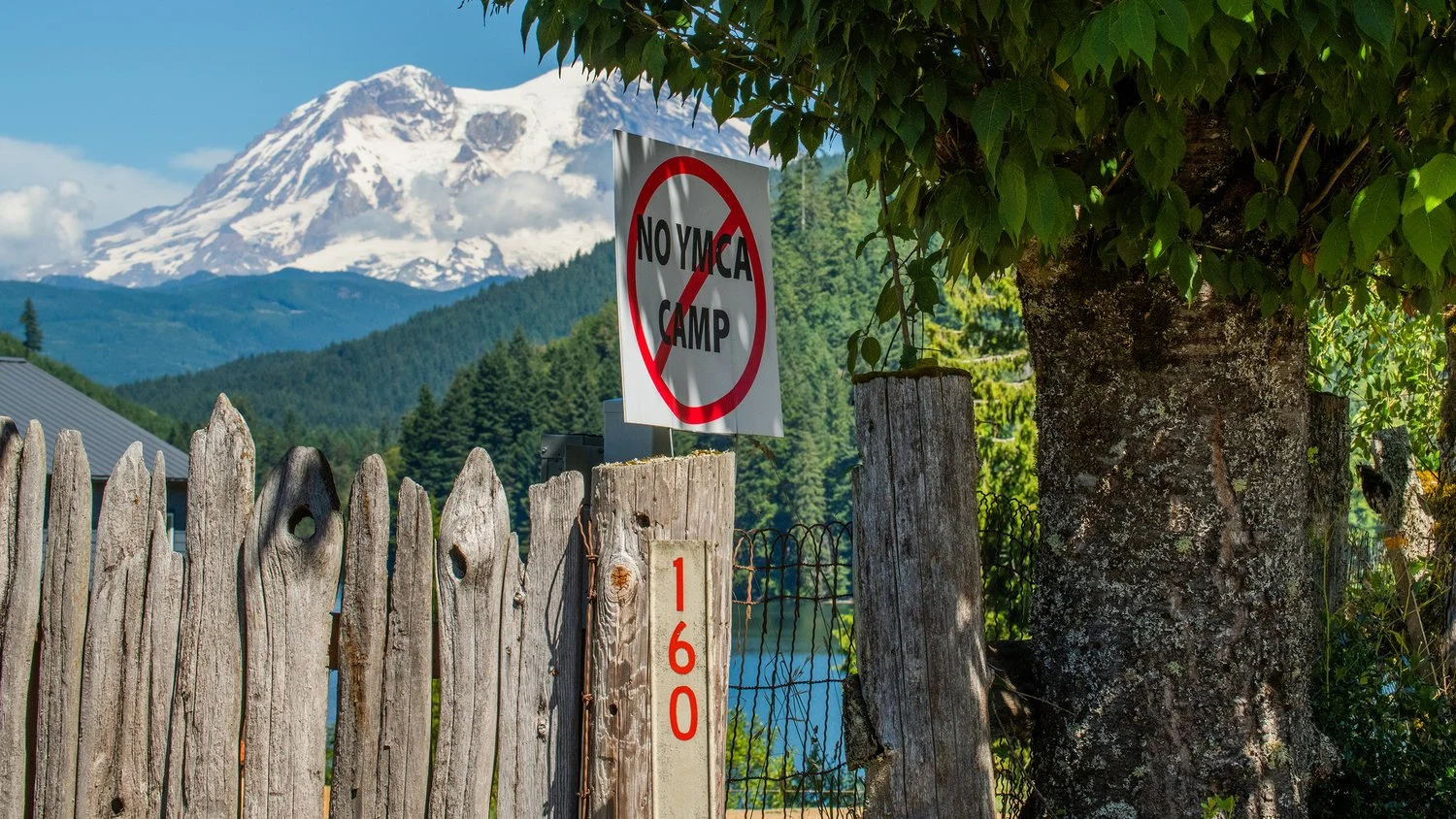 Signs posted around Mineral Lake display opposition for a proposed YMCA summer camp location.