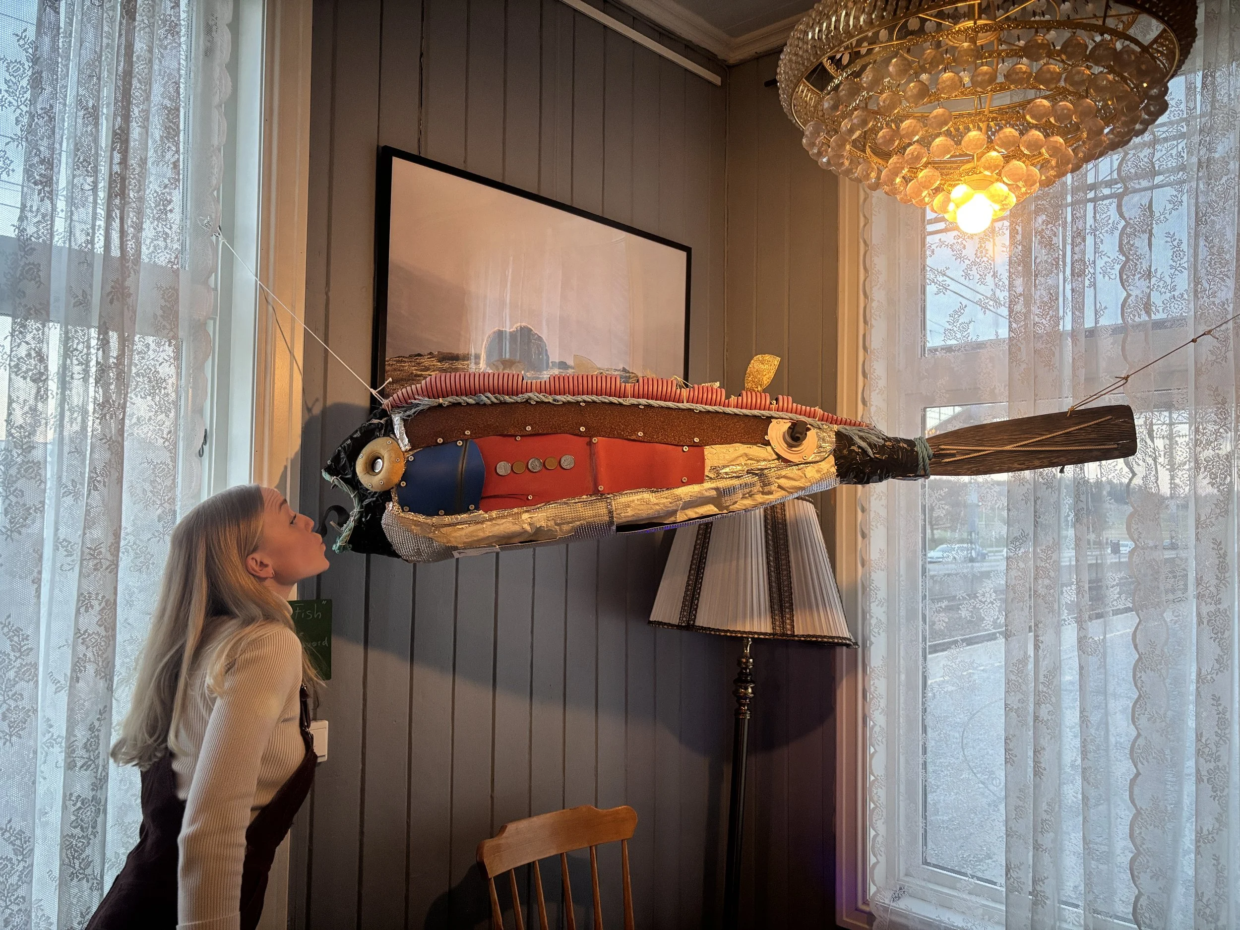 Marianne Vik kissing the big fish sculpture.