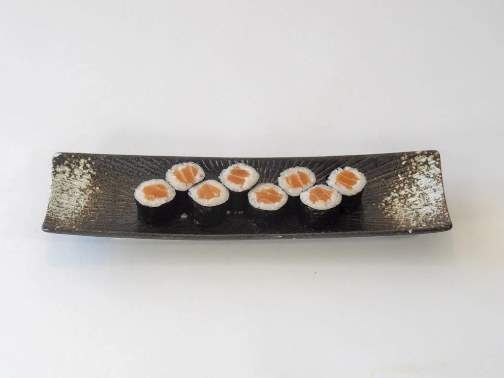 Sushi rolls with salmon on white background.