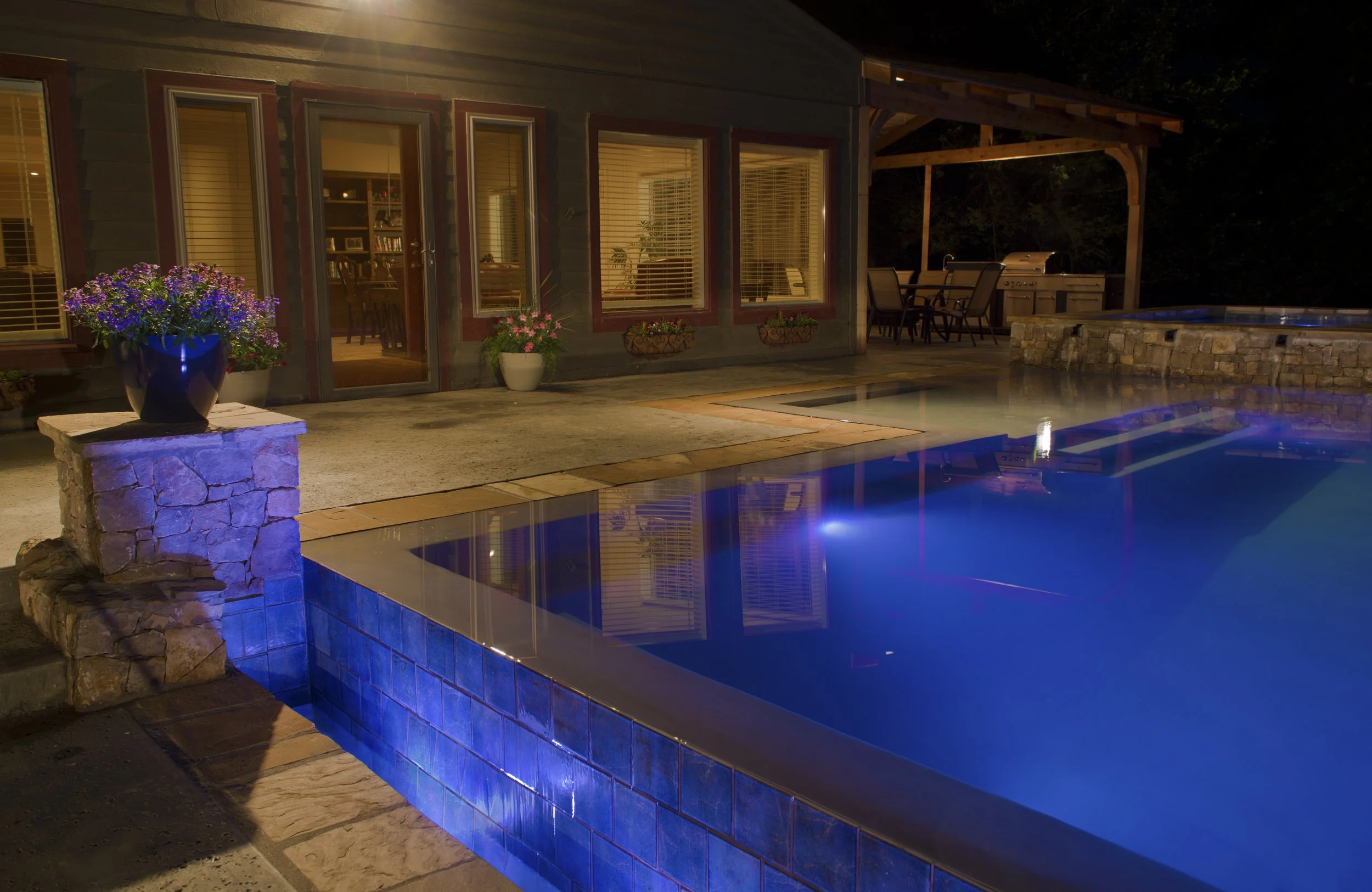 This custom resort-style pool project was designed as a complete backyard destination, combining luxury entertaining spaces with family-friendly features. The upper adult pool includes a vanishing edge and perimeter overflow detail, creating a clean,