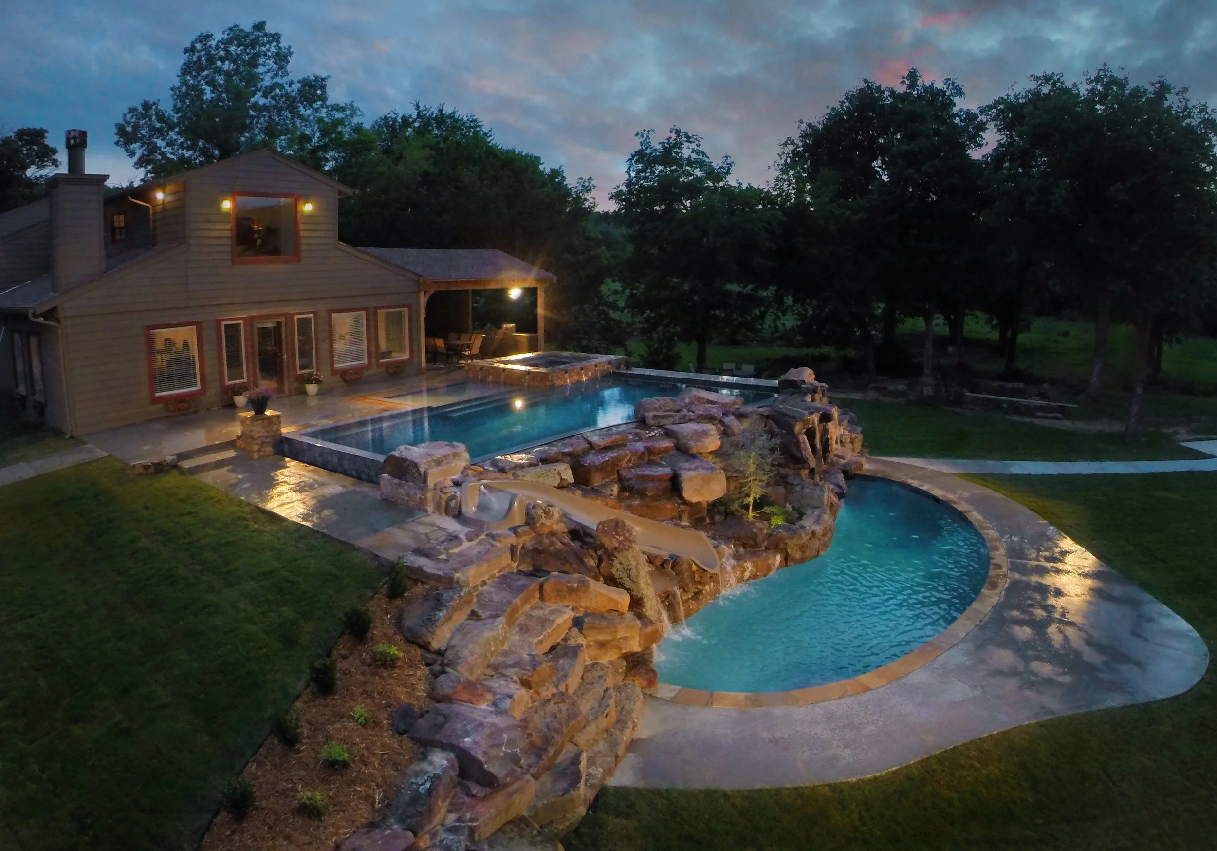 This custom resort-style pool project was designed as a complete backyard destination, combining luxury entertaining spaces with family-friendly features. The upper adult pool includes a vanishing edge and perimeter overflow detail, creating a clean,