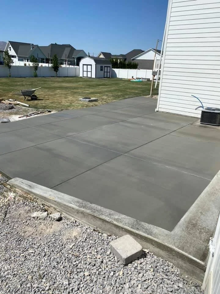 Newly poured concrete patio in a backyard.