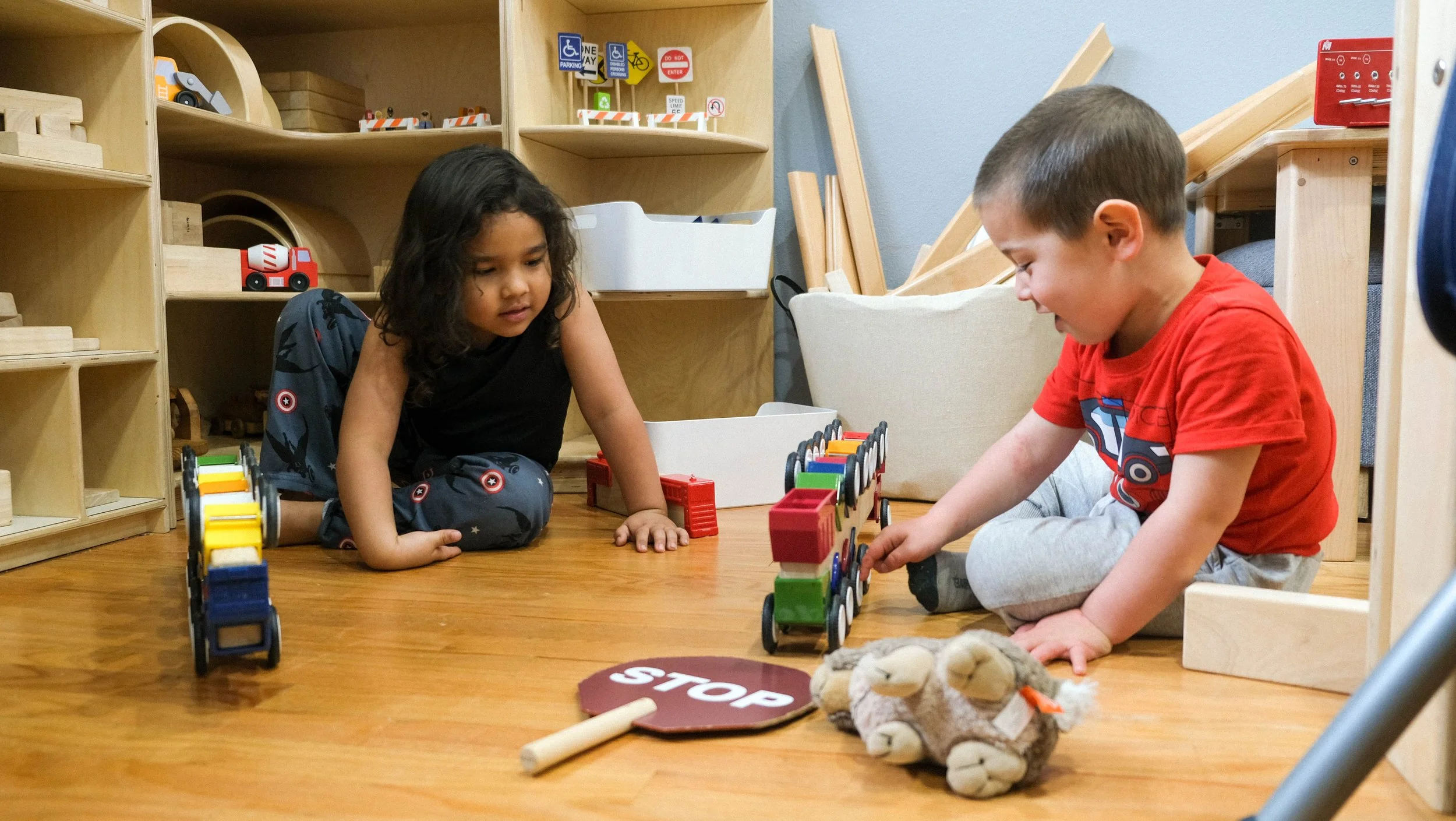 Pre-K at Global Early Learning in Bellevue, Washington playing with wooden small toys during free play. Hands on learning and free play is encouraged.