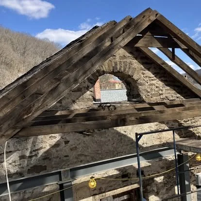 Removing roof rafters. Packer Mansion through vent window.