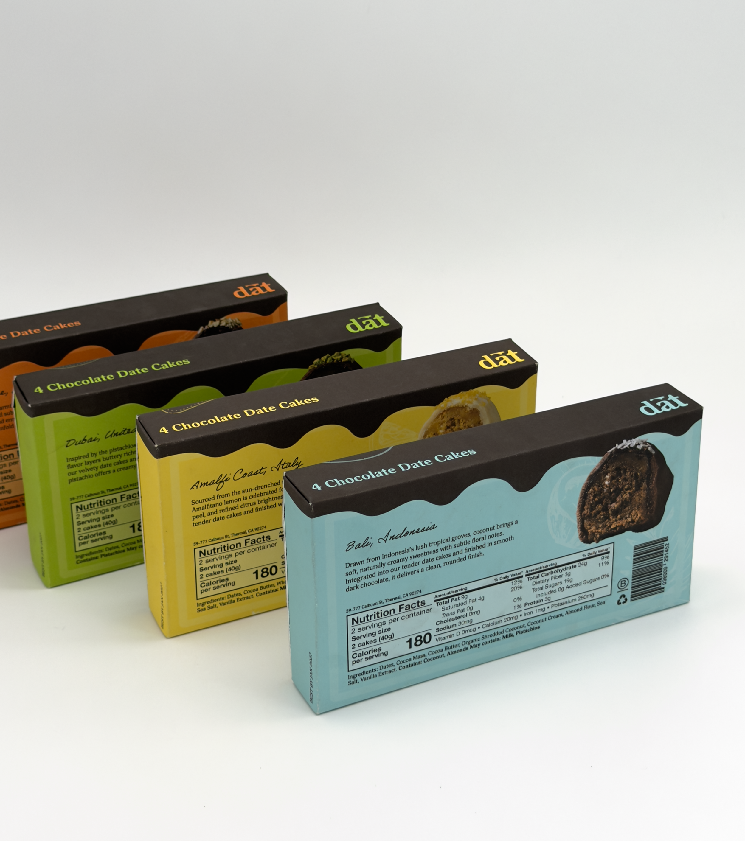 Four boxes of chocolate date cakes in different flavors and colors, arranged in a row on a white background.