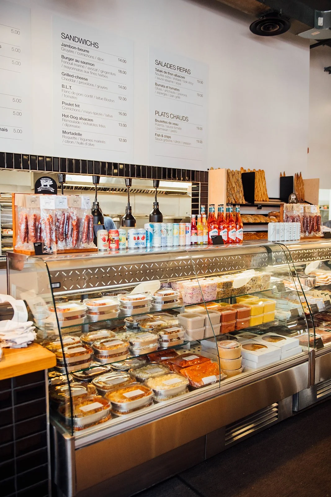 Comptoir d'épicerie fine avec charcuteries, condiments et produits importés.
