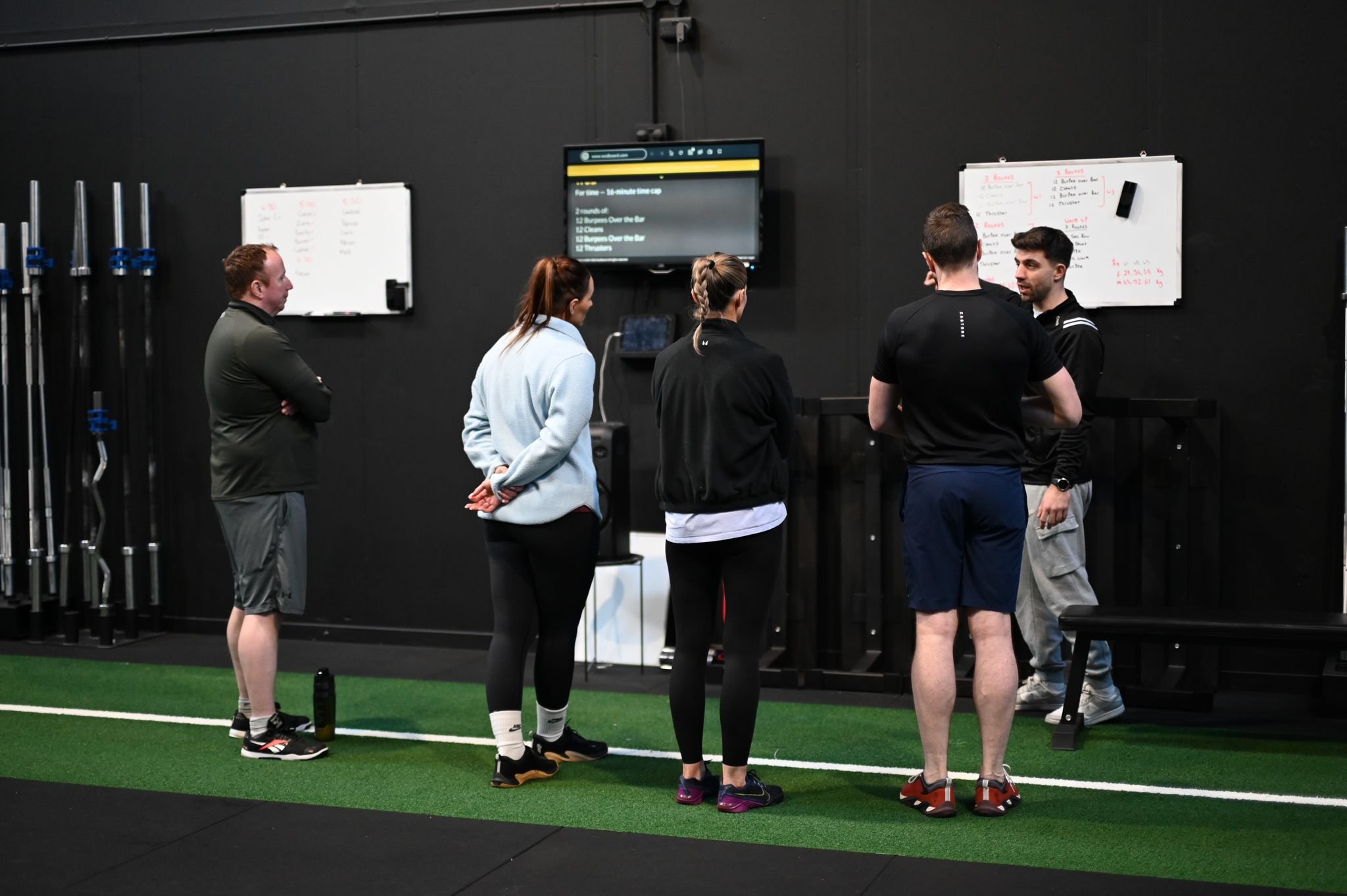 Coaches briefing athletes around the programming whiteboard before a Metcon class at Alliance Training Club Letterkenny