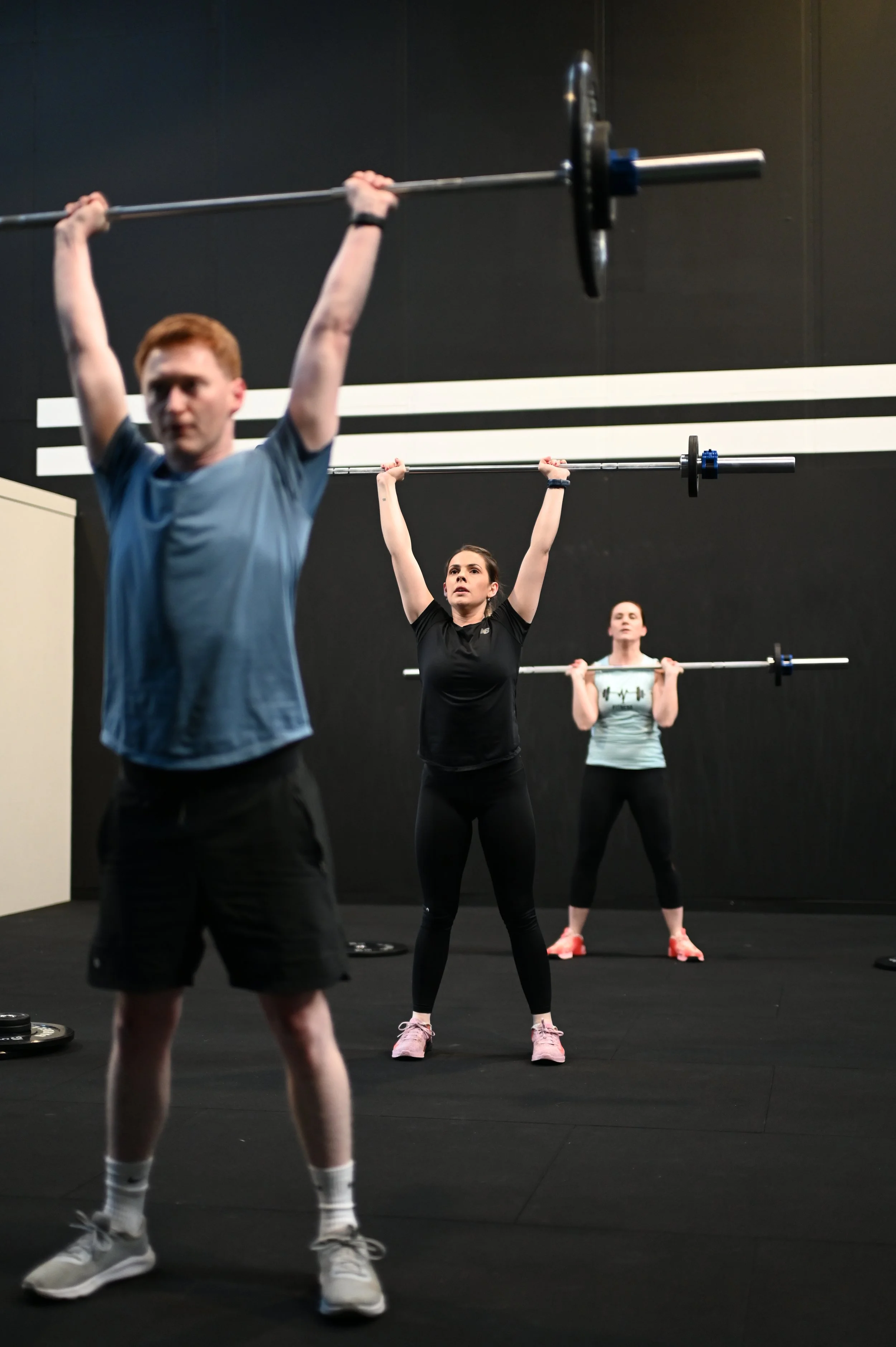 Athletes performing shoulder presses at Alliance Training Club