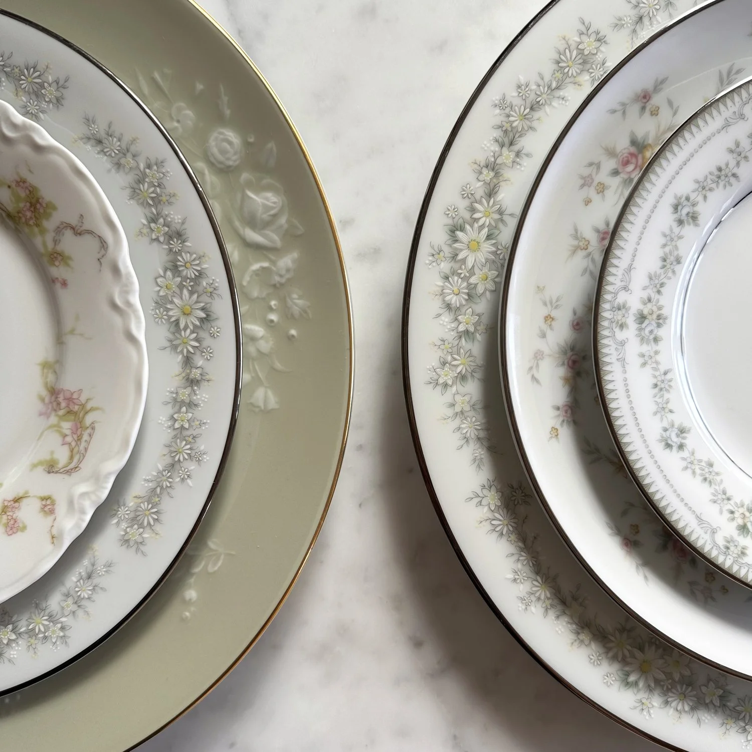 Detailed heirloom vintage china featuring mixed and matched dinner, salad, and bread and butter plate that can also be used as a festive cake plate.