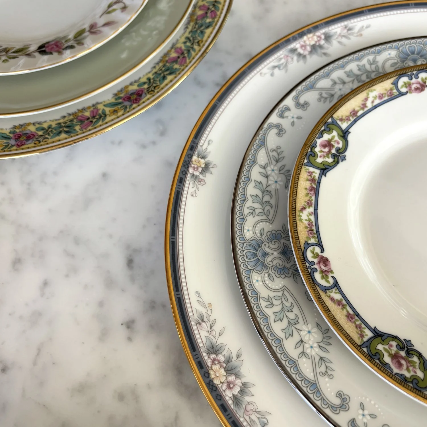 Two close up, detail shots of floral mixed and matched dishware.