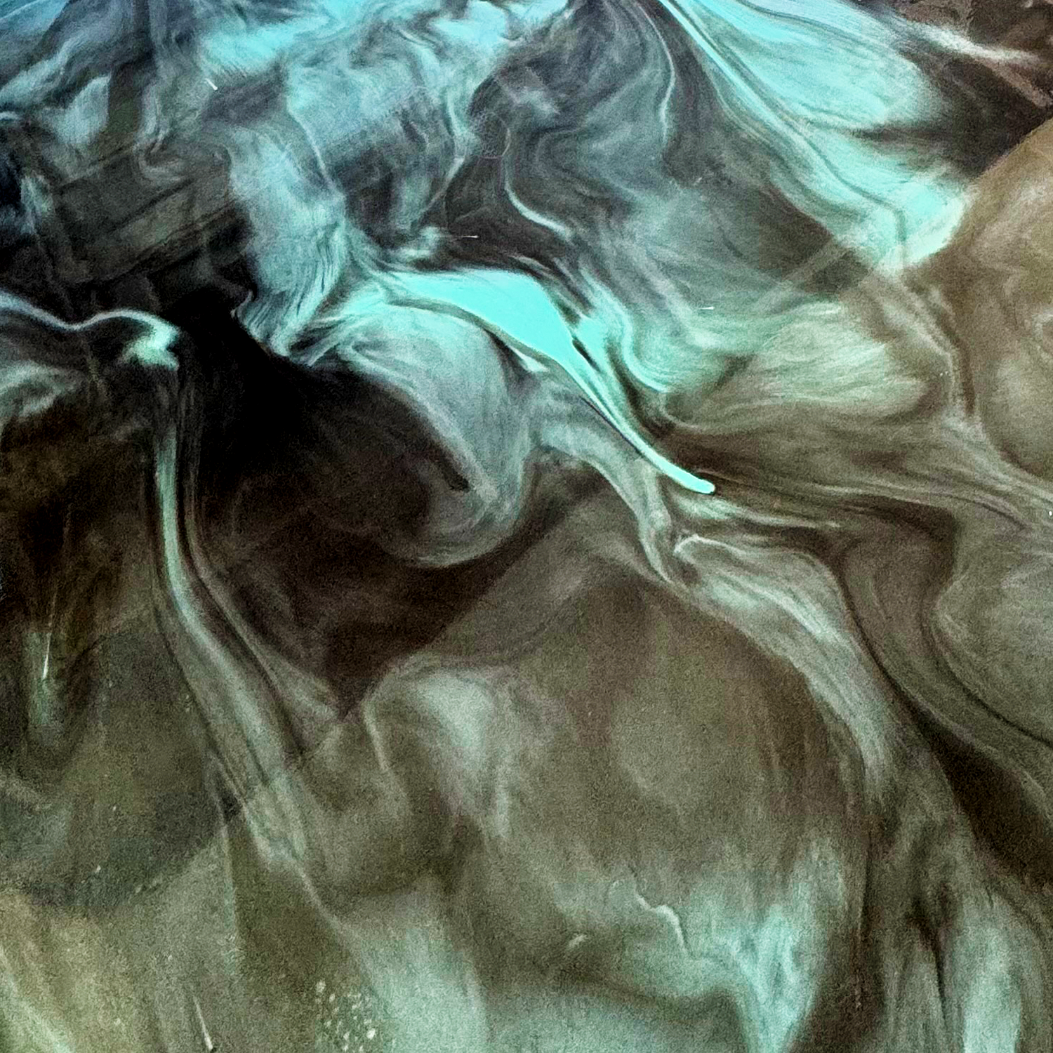 Abstract swirling epoxy pattern with shades of black, gray, and teal.