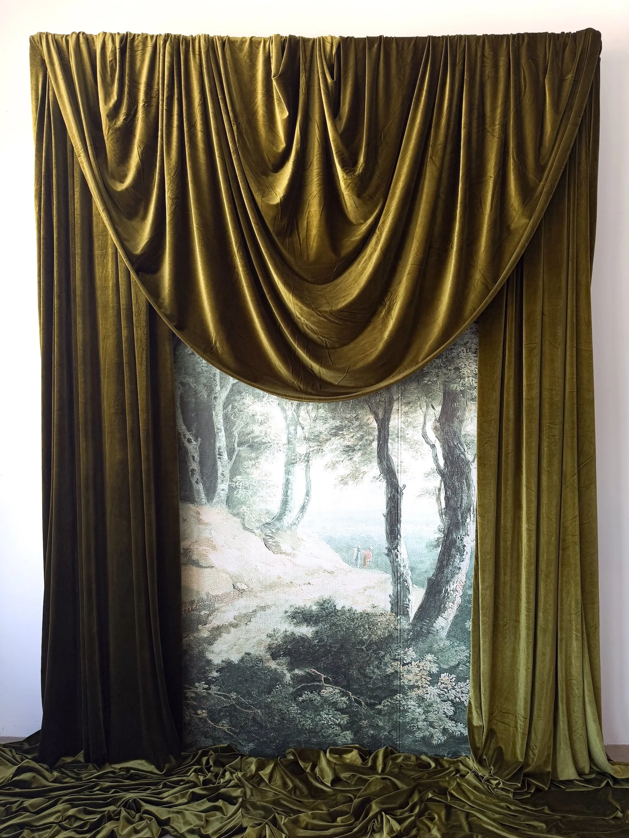 Gold velvet curtains partly open to reveal a painted nature scene of trees and a figure walking in a misty landscape.