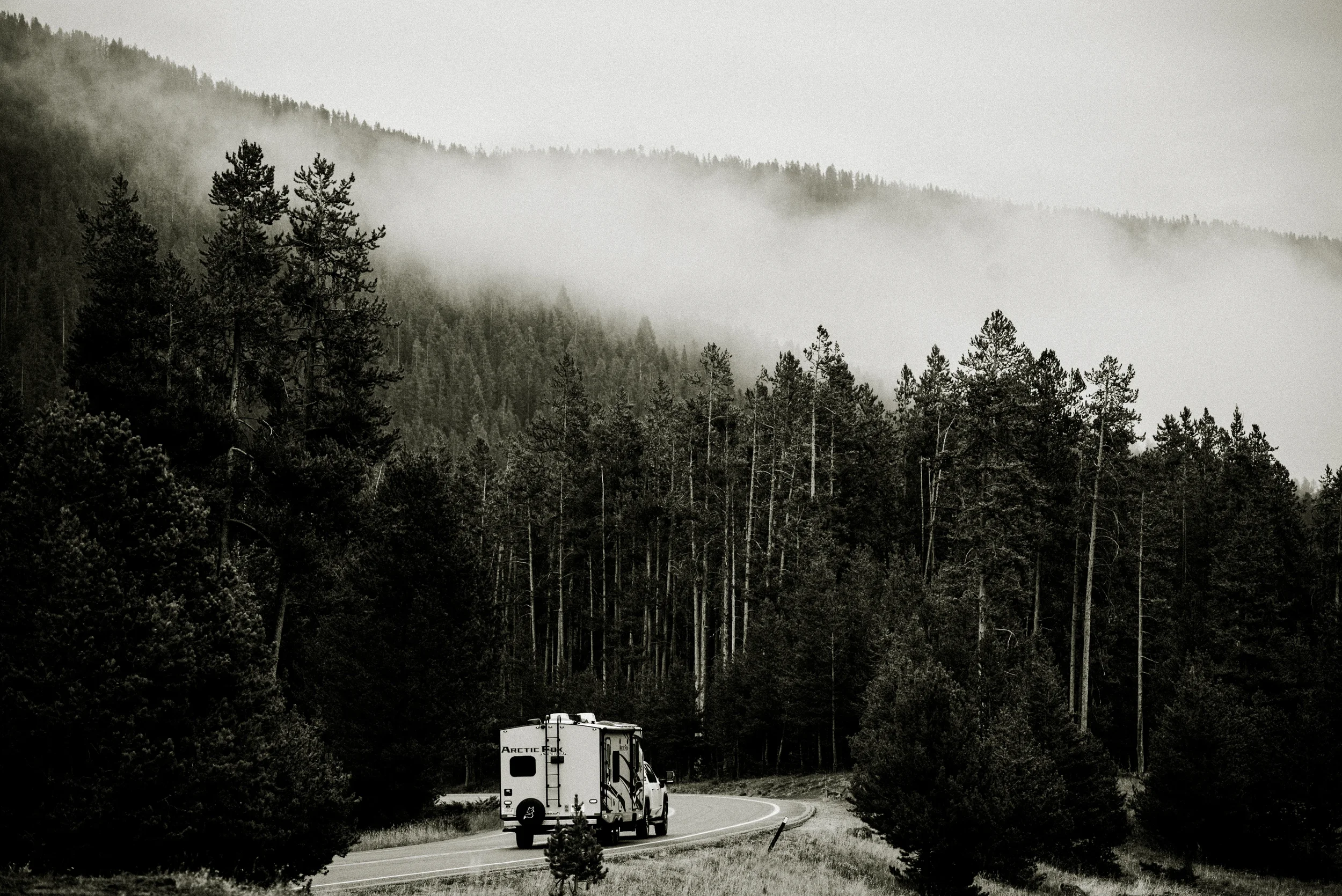 truck and camper driving through yellowstone