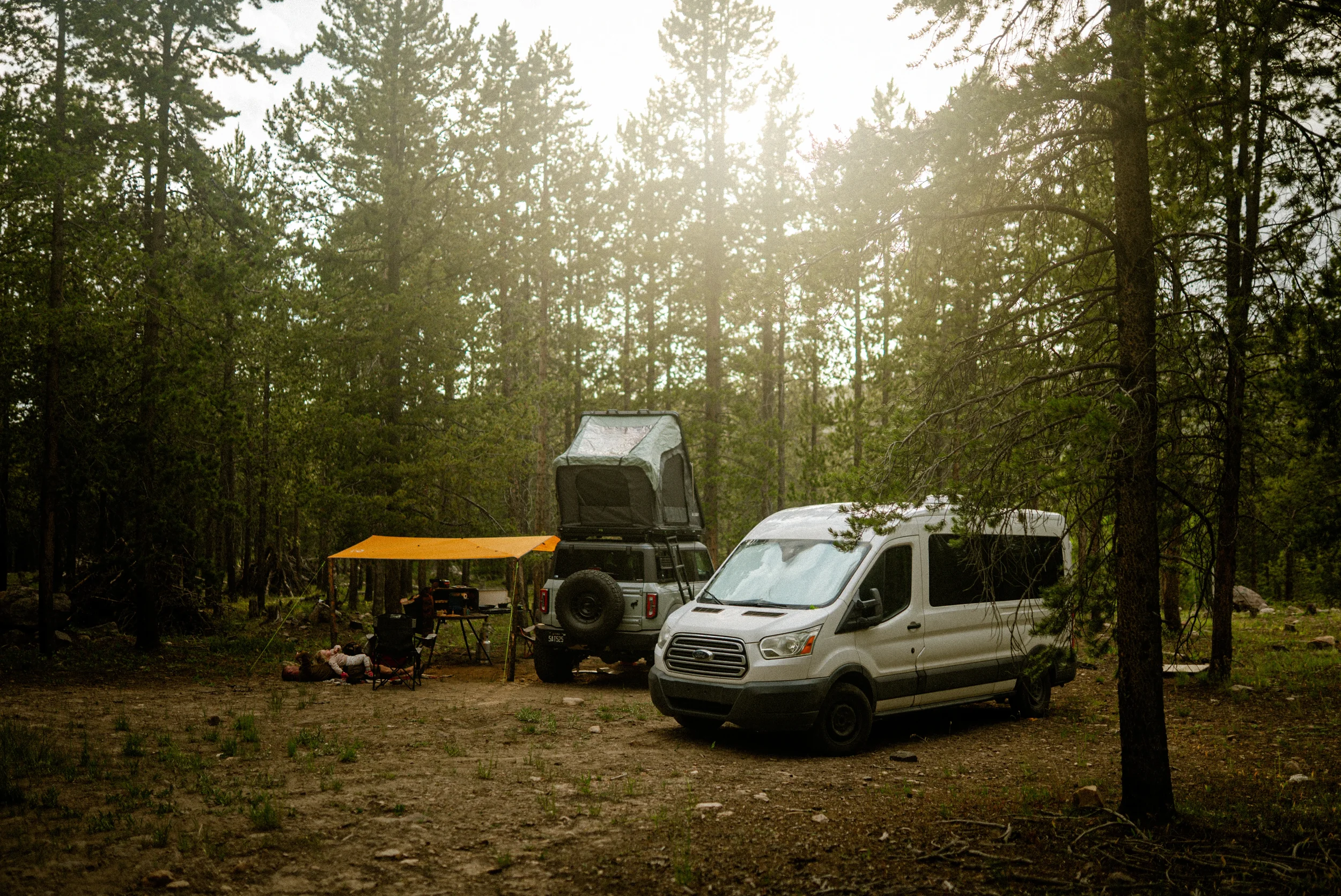 a van and bronco camping in the forest