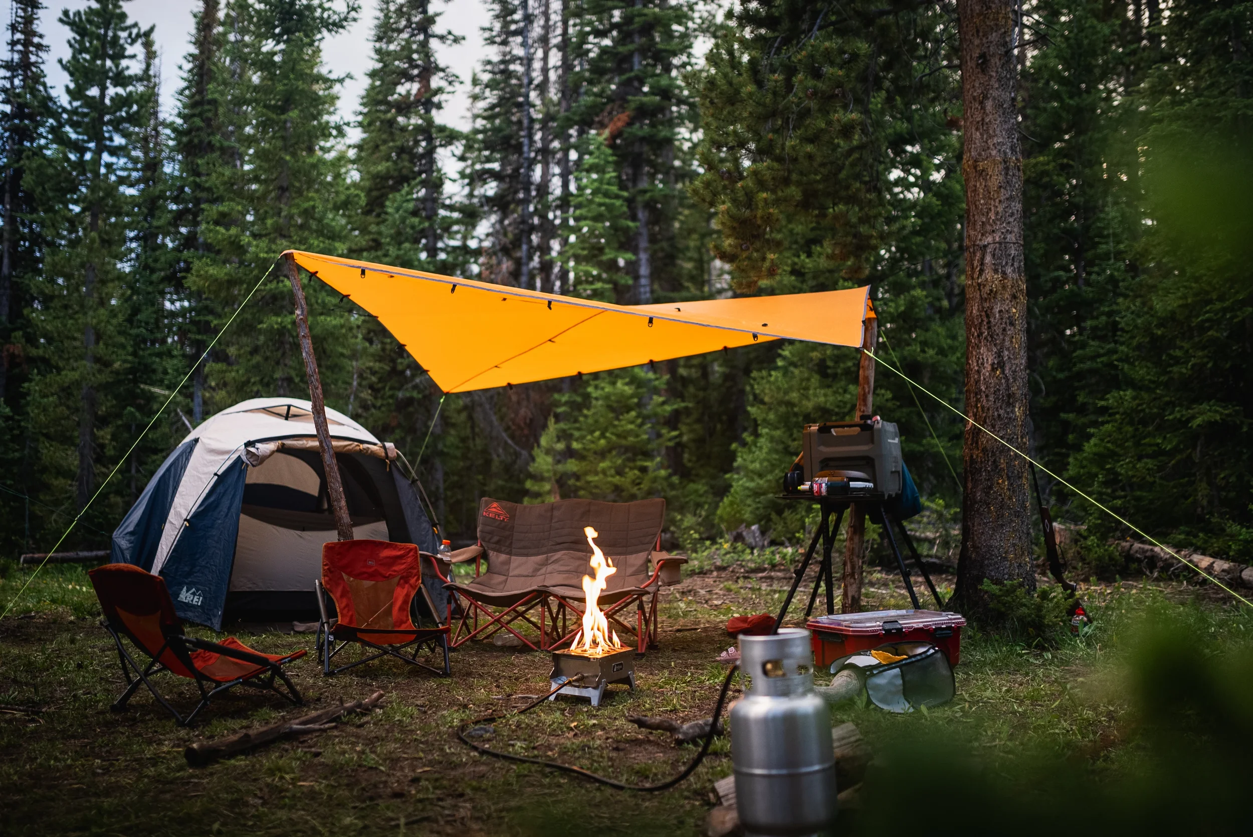 camp setup with tent fire pit and tarp
