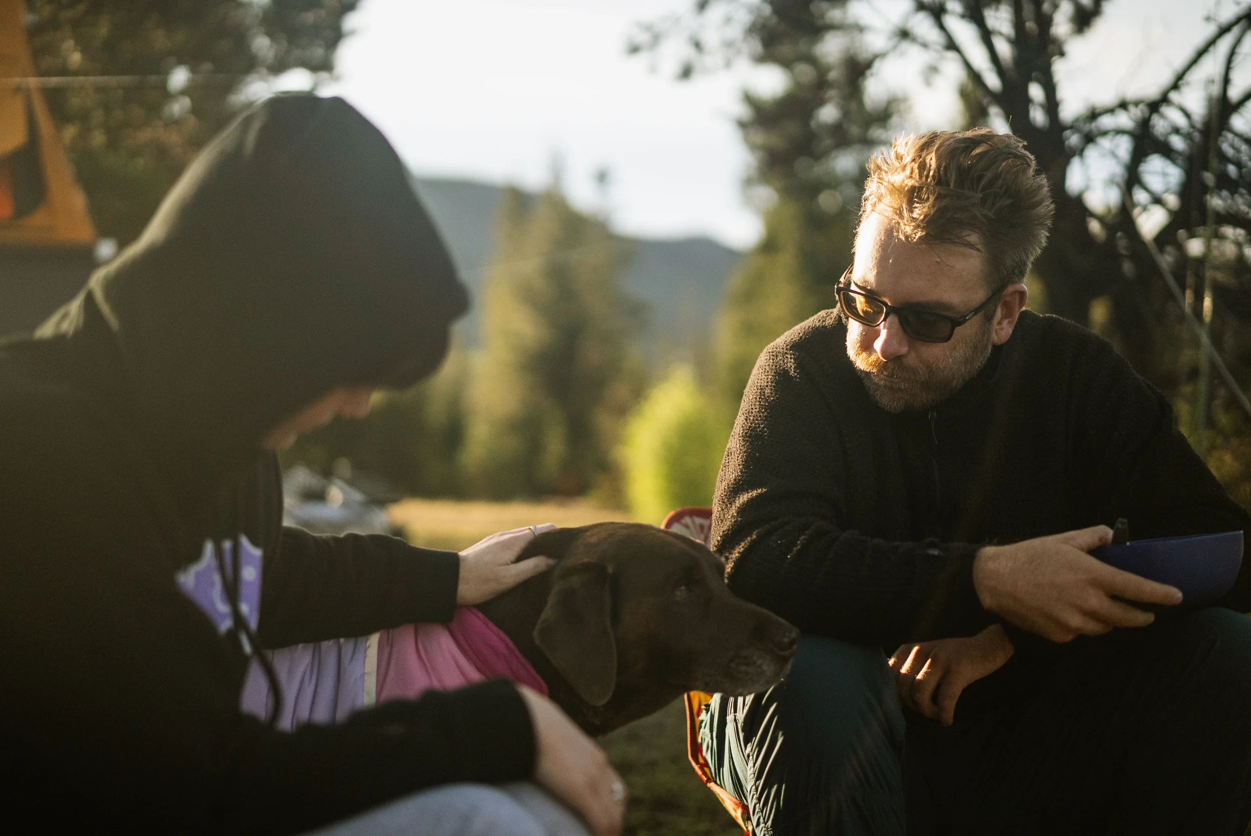 man and woman petting a dog