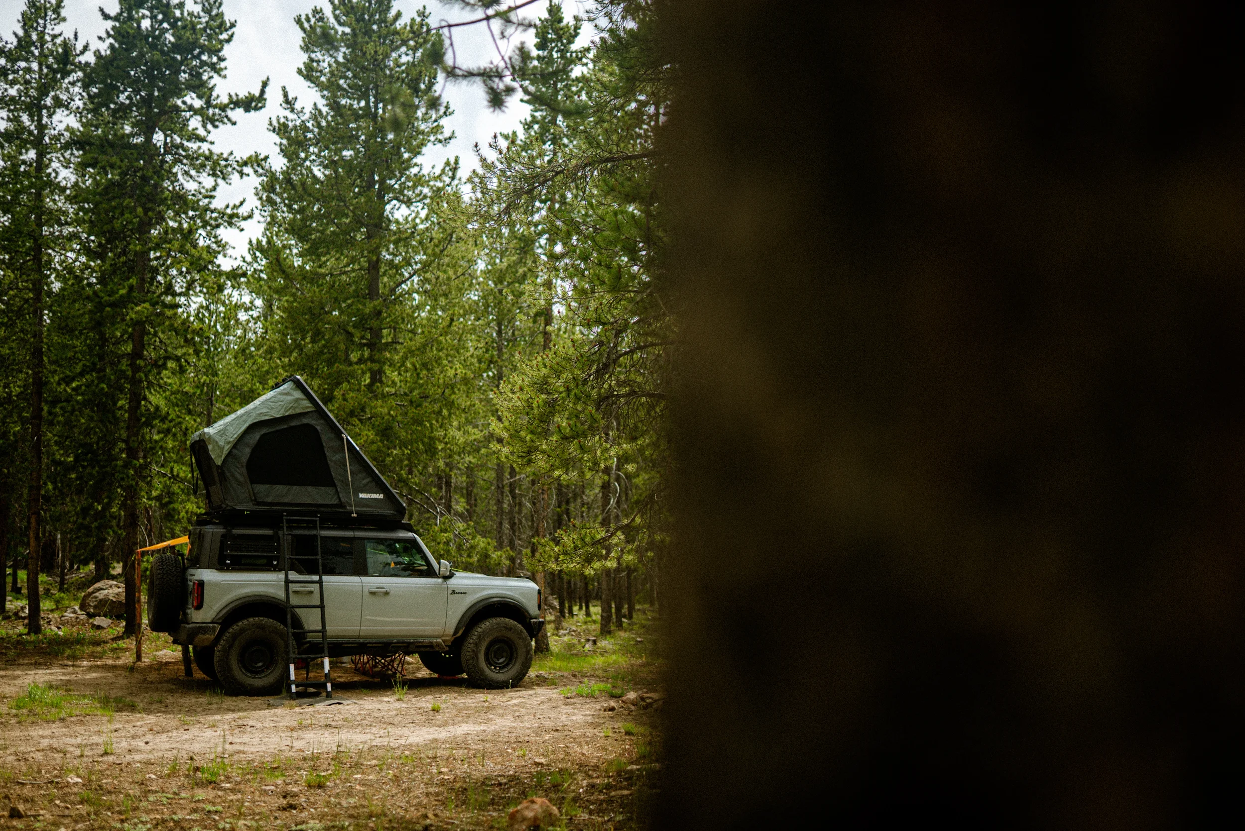 bronco with roof top tent camped in the forest