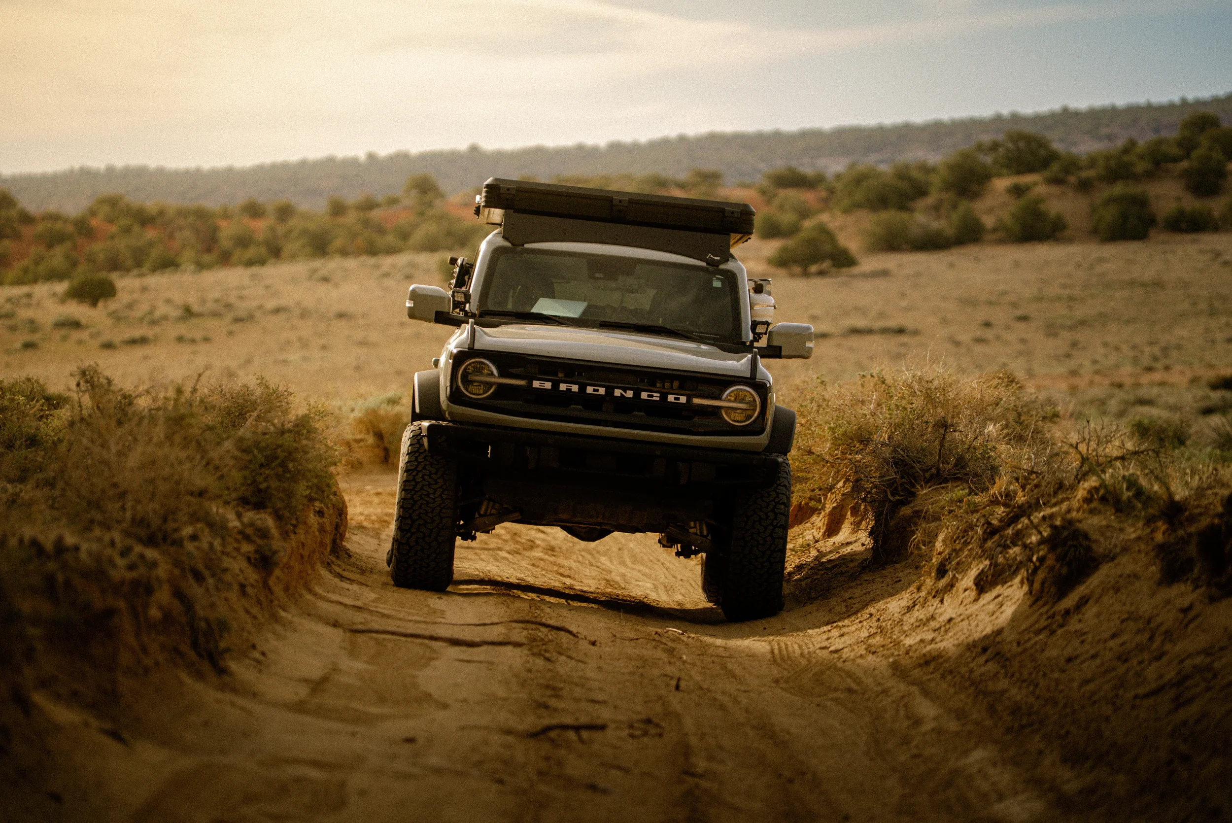 ford bronco on 37s on a sandy road