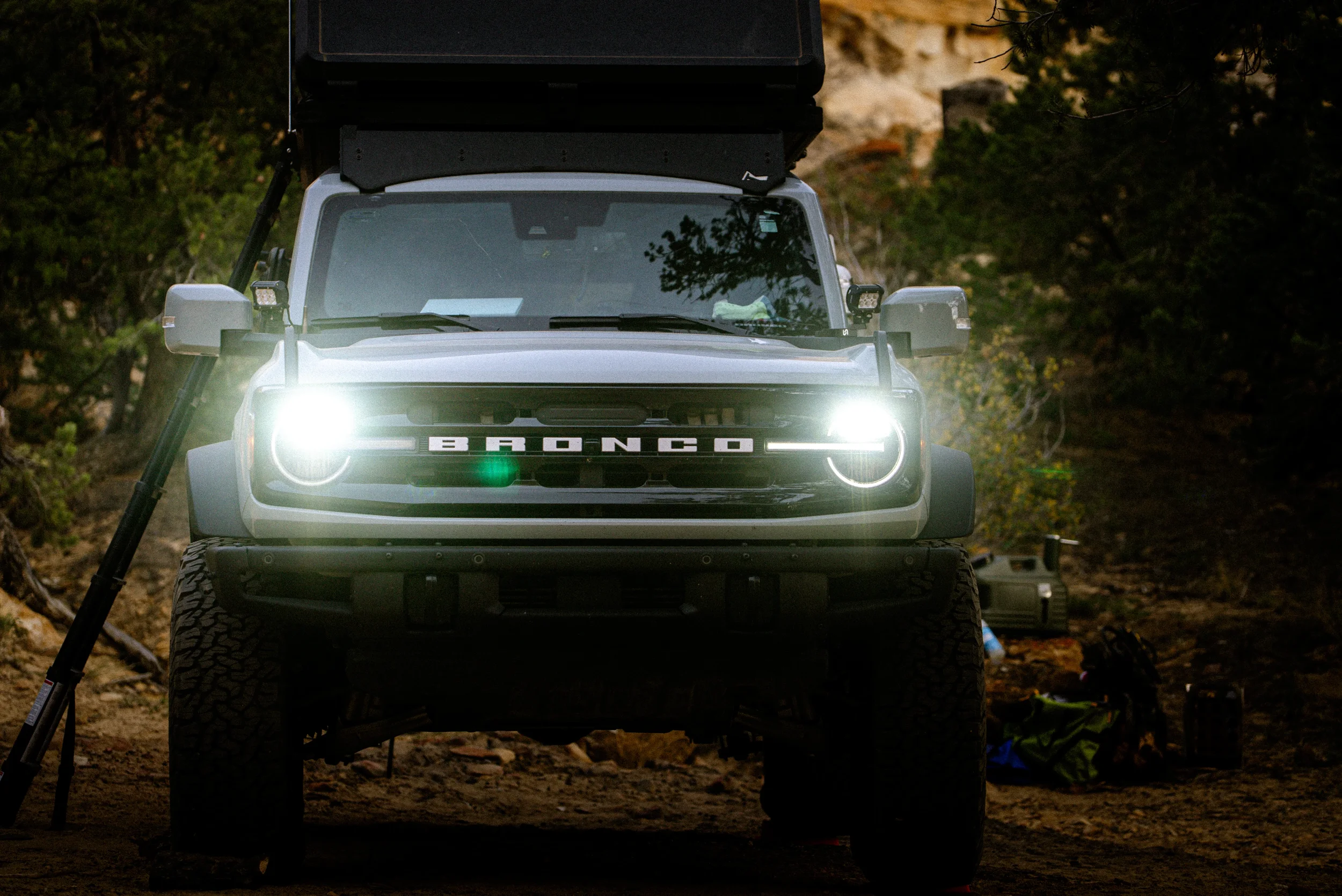 ford bronco with rooftop tent and headlights on