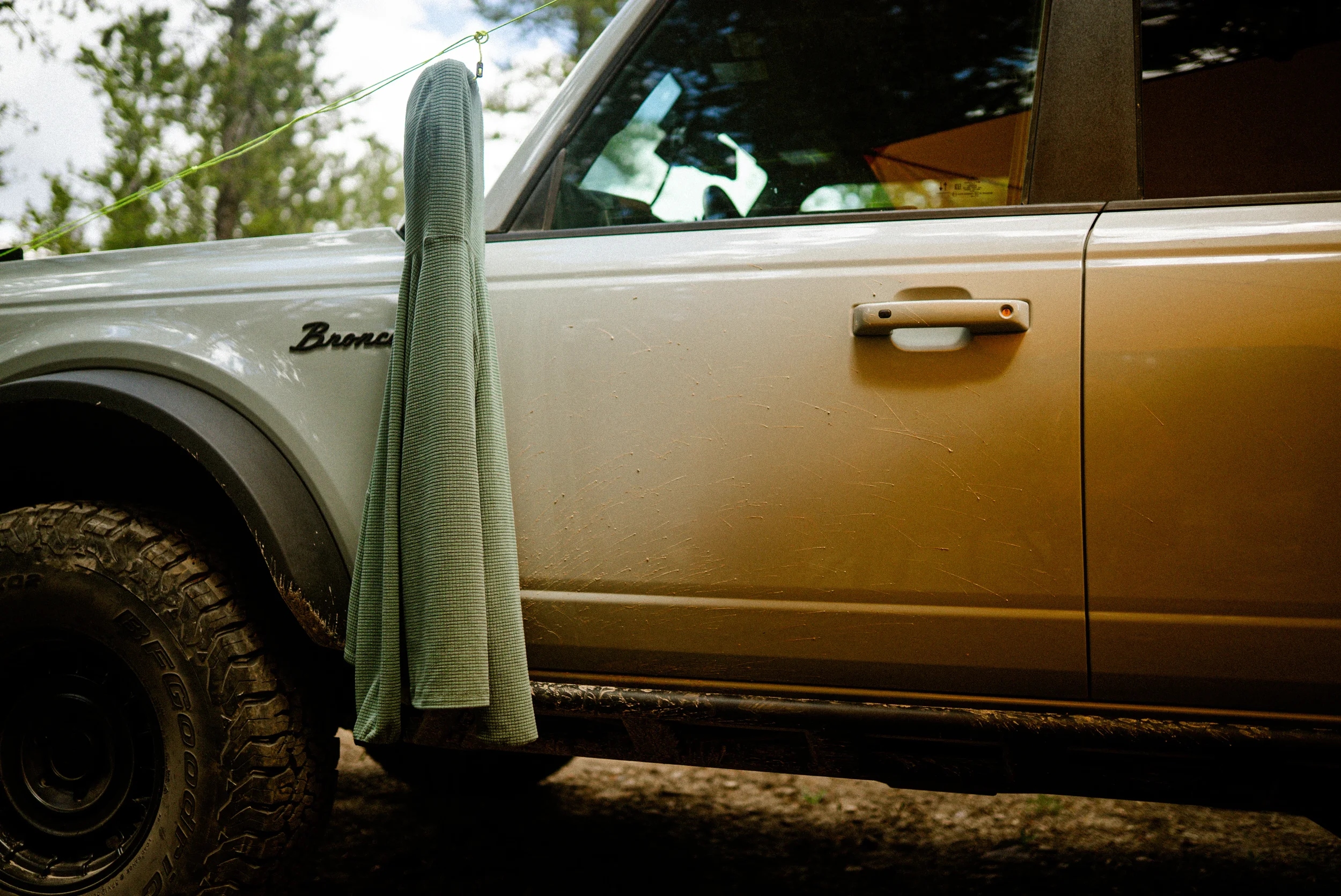 green jacket hanging on a bronco mirror