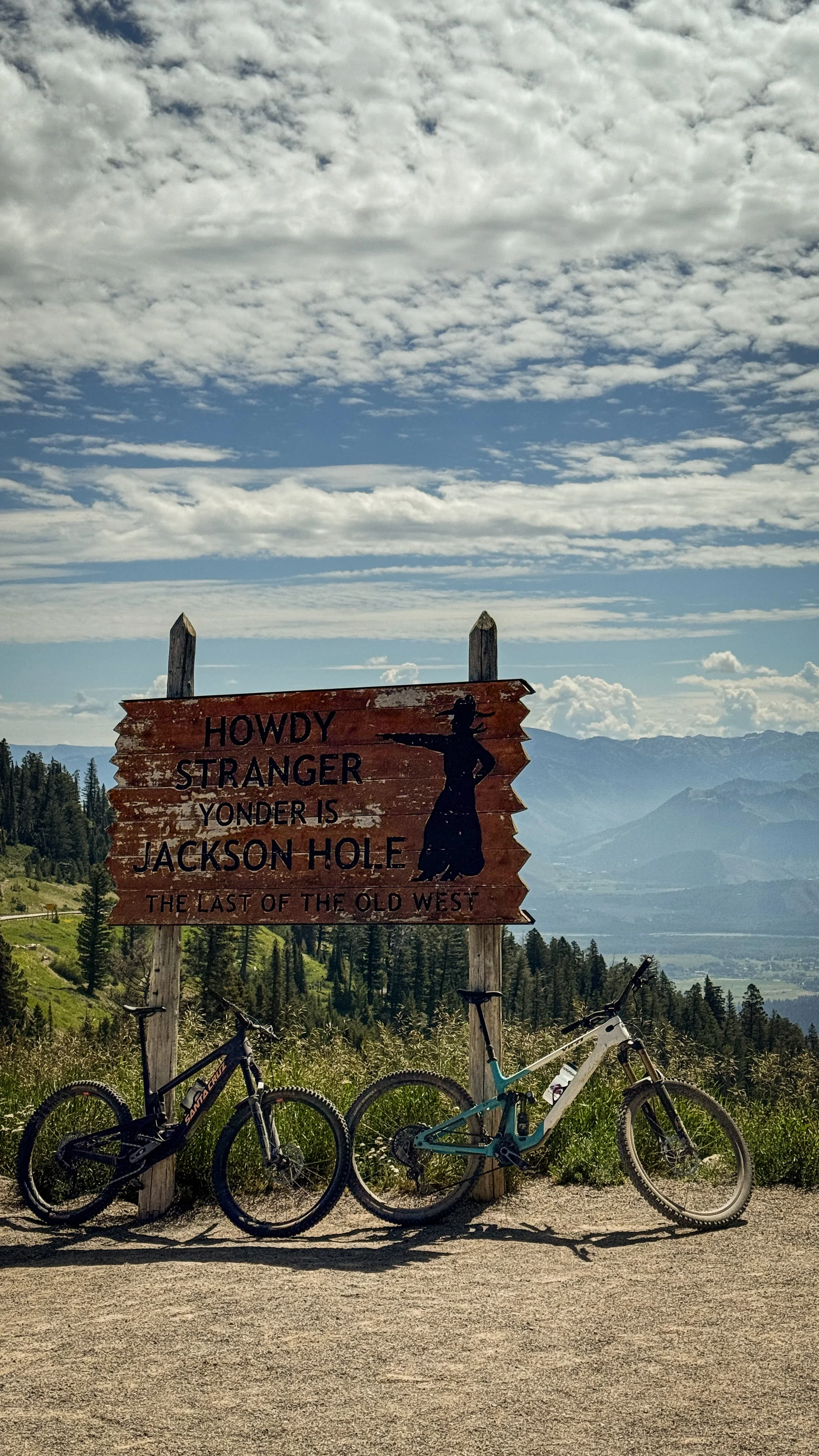 mountain bikes leaning against the famous teton pass sign