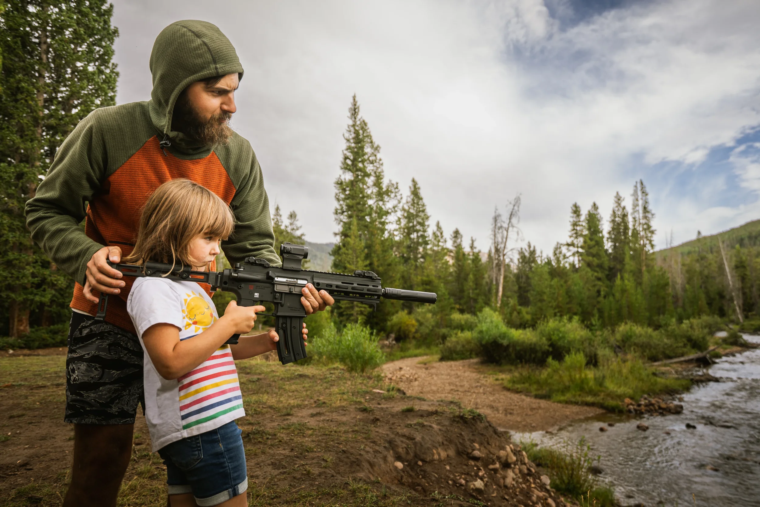 Man and young kid shooting a rifle