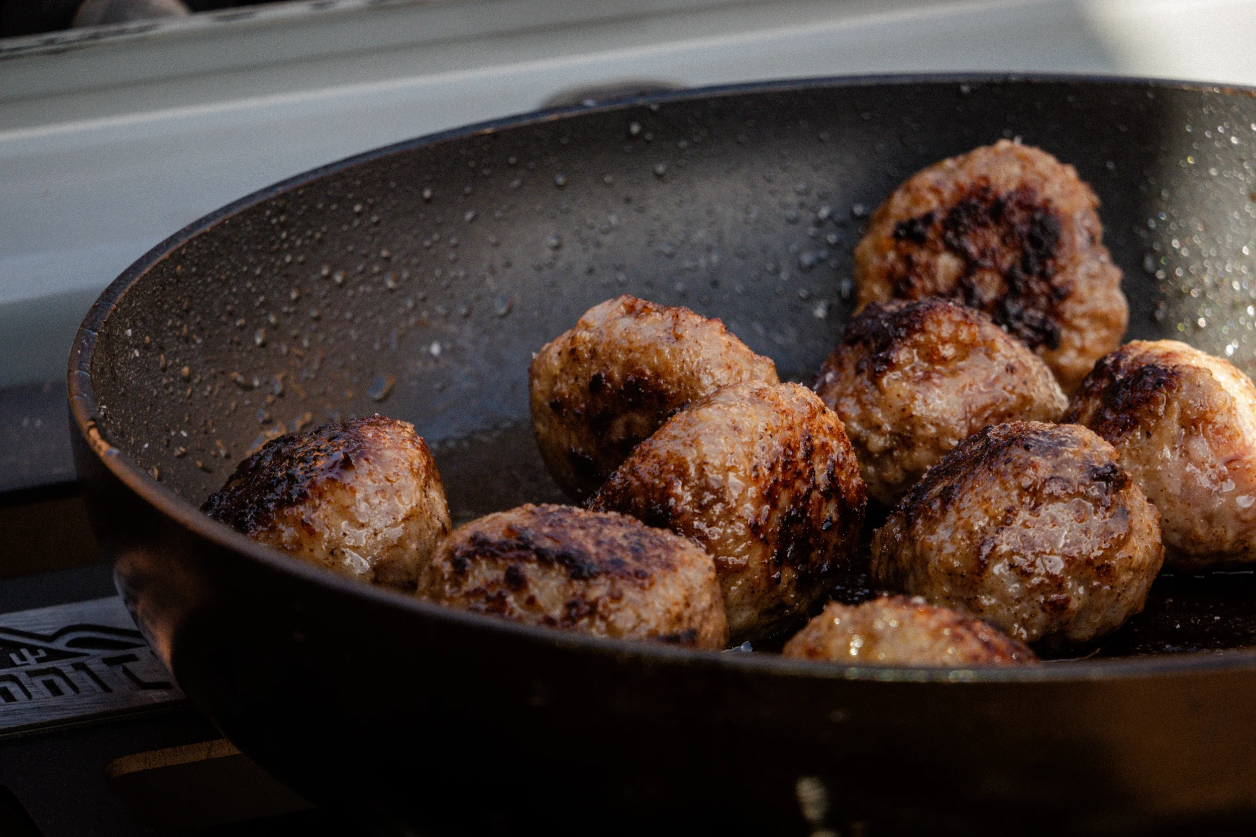 meatballs searing in a pan