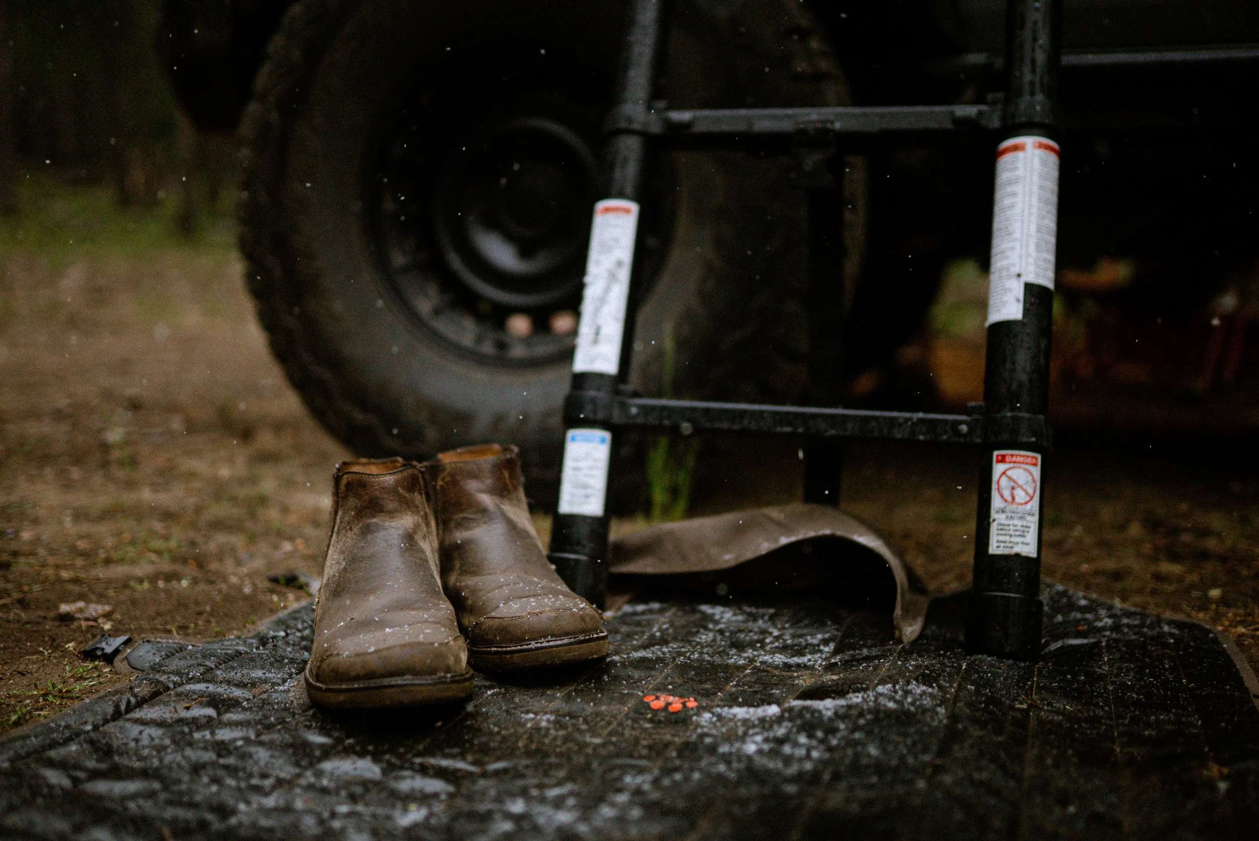 wet boots on the ground outside a tent