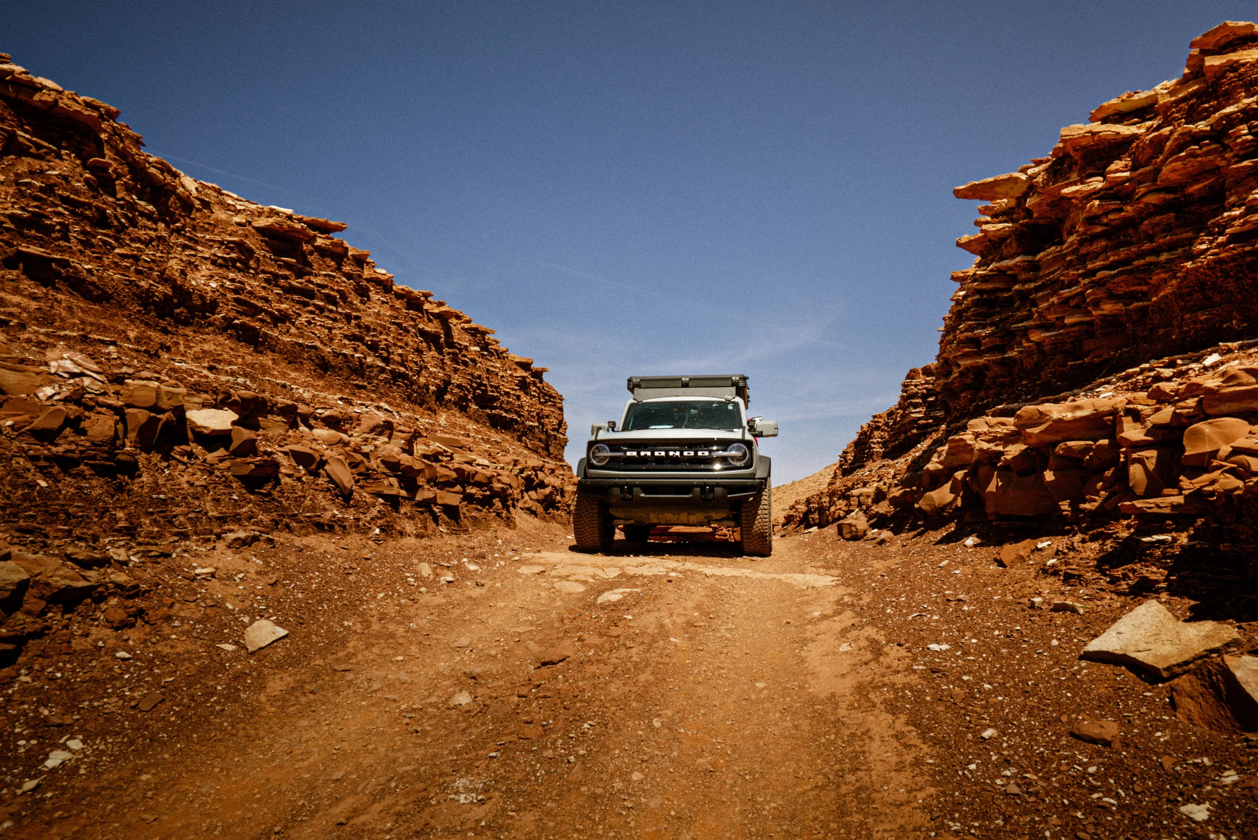 bronco between two rock walls on the white rim