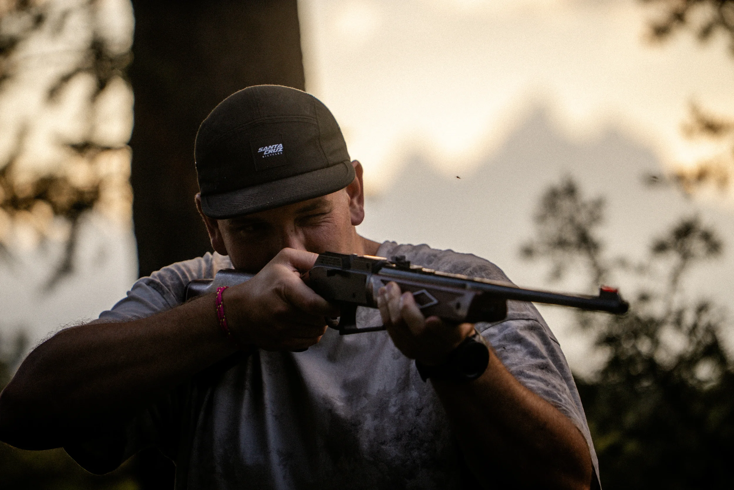 man shooting a bb gun with a mosquito in his ear