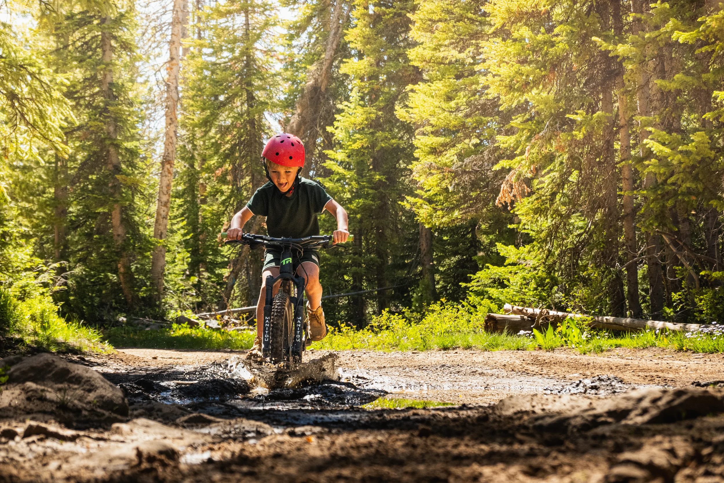 child riding a bike in a muddy pudle